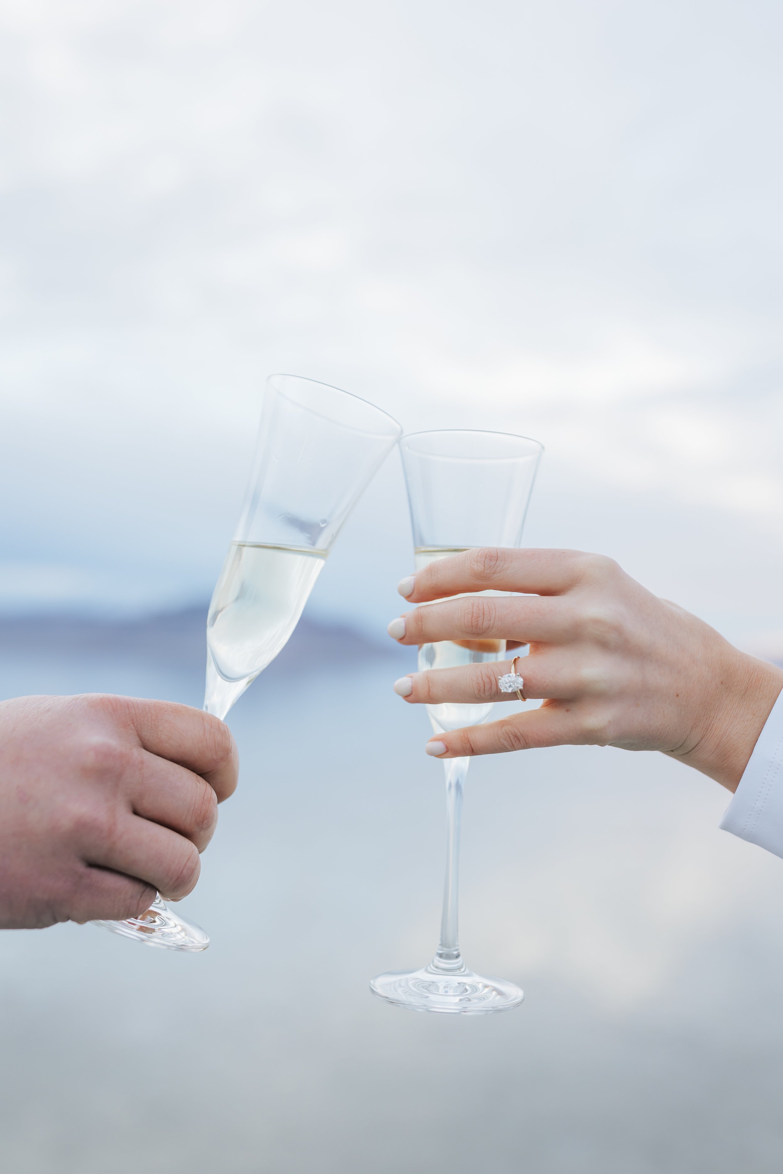  A detailed photograph of two glasses being toasted together at Lake Bonneville Salt Flats captured by Emily Jenkins Photography. toasting glasses at the Salt Flats engaged couple #EmilyJenkinsPhotography #EmilyJenkinsEngagements #BonnevilleSaltFlats