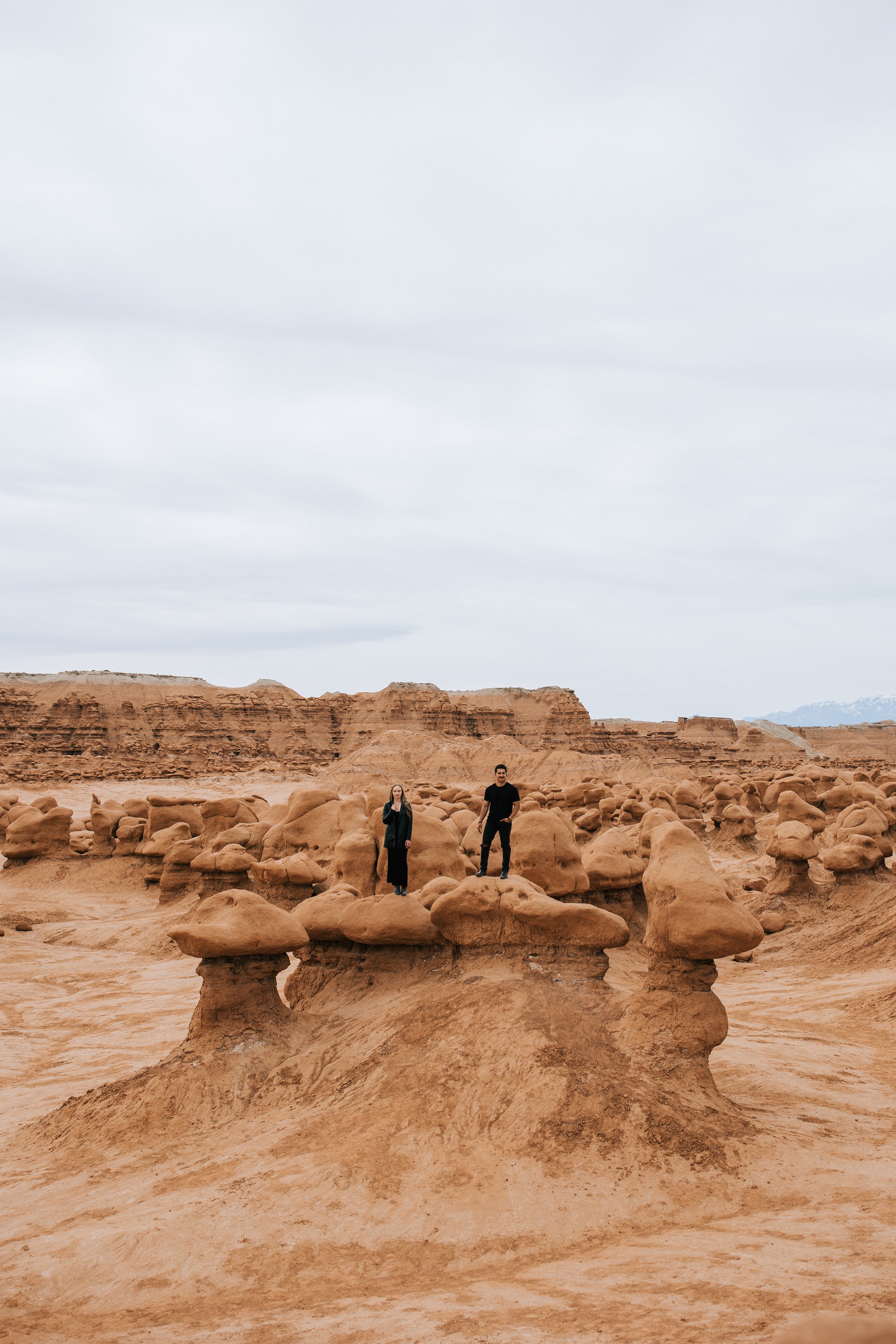  An engaged couple wears all-black outfits in the middle of Goblin Valley for a trendy engagement session with Emily Jenkins Photography. trendy engagement natural engagement portraits #EmilyJenkinsPhotography #EmilyJenkinsEngagements #HanksvillePhot