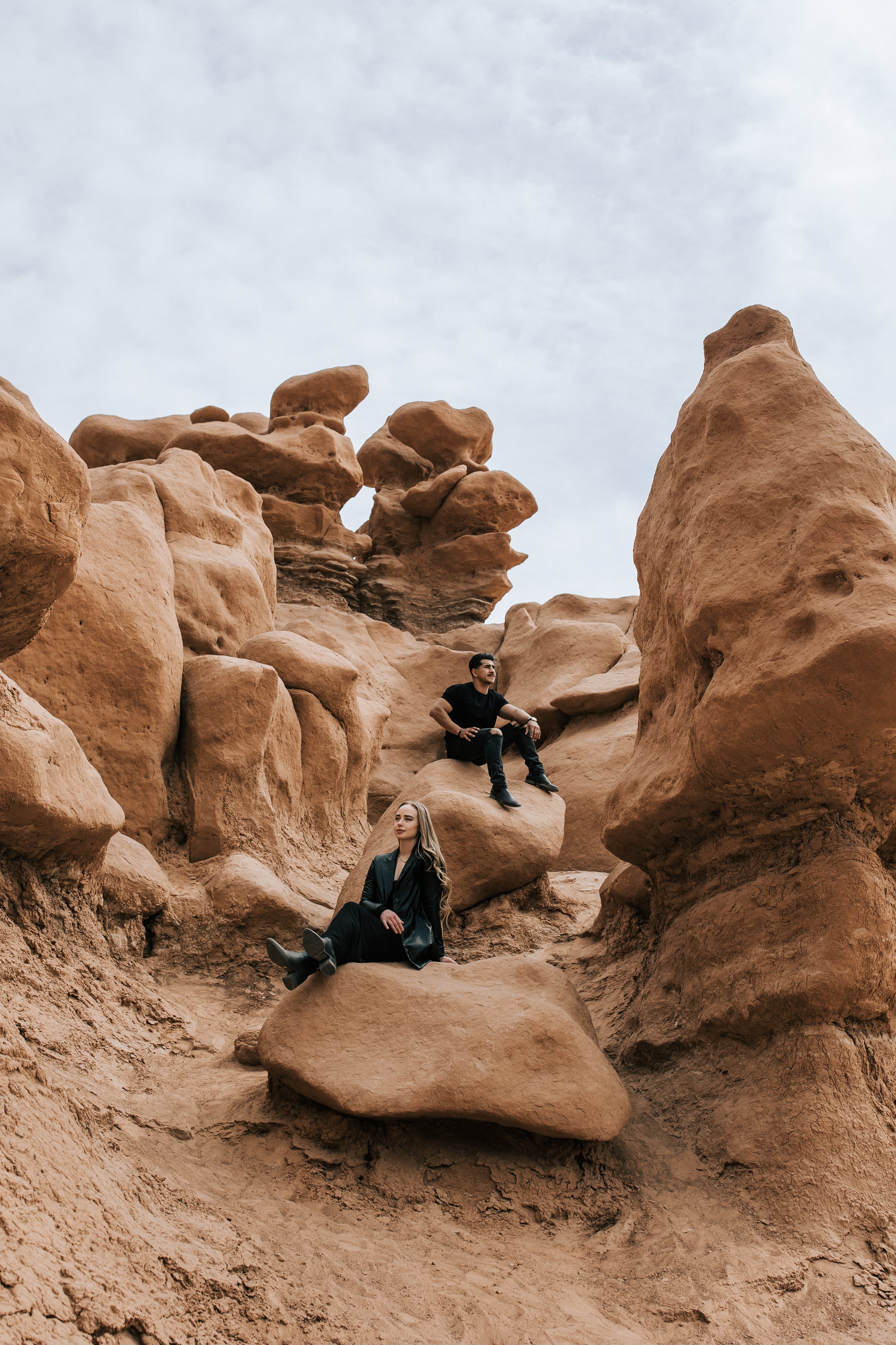  A dynamic modern engagement photograph of a couple sitting on red rocks in Goblin Valley by Emily Jenkins Photography. modern engagement hippie engagement style #EmilyJenkinsPhotography #EmilyJenkinsEngagements #HanksvillePhotography #GoblinValleyEn