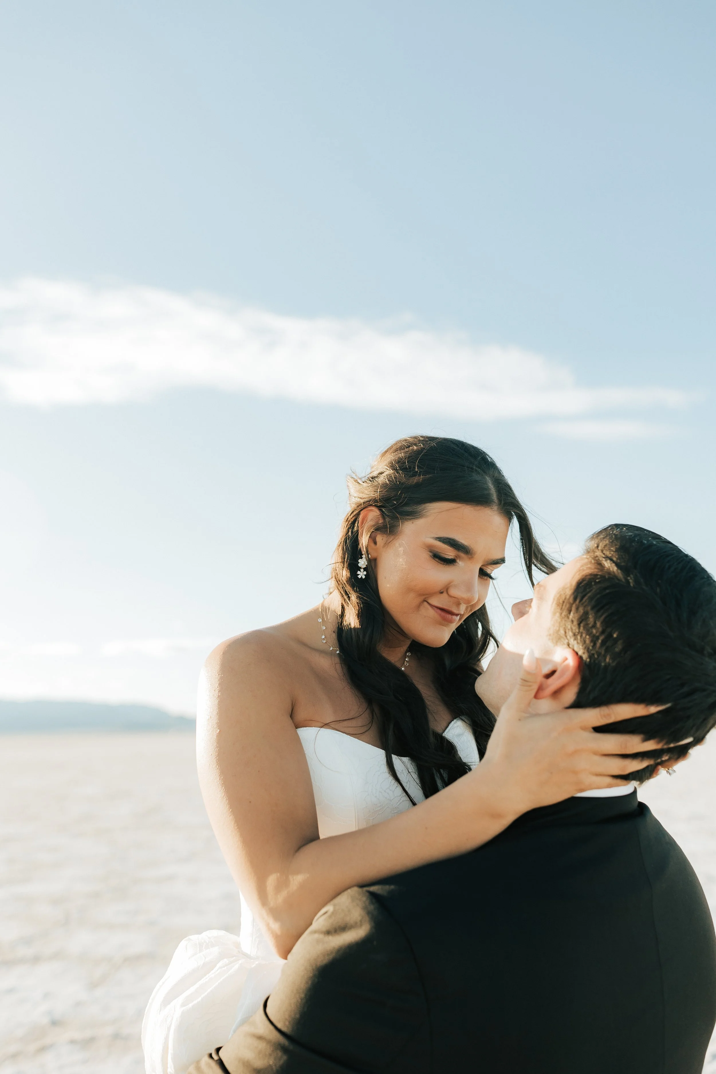  Groom lifts his bride after their wedding at the Bonneville Salt Flats at golden hour 