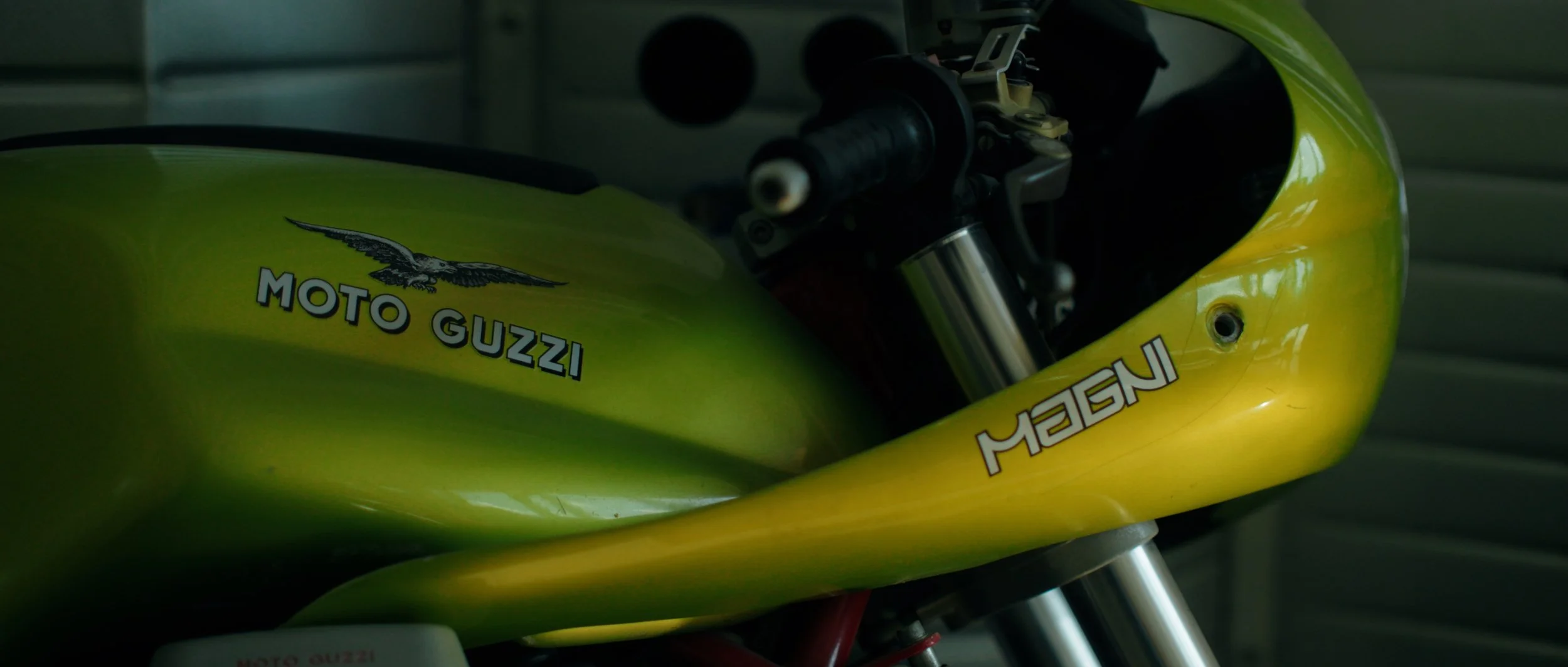 Close-up of a yellow Moto Guzzi motorcycle with a falcon logo and the words 'MOTO GUZZI' and 'MSEN' on the body.