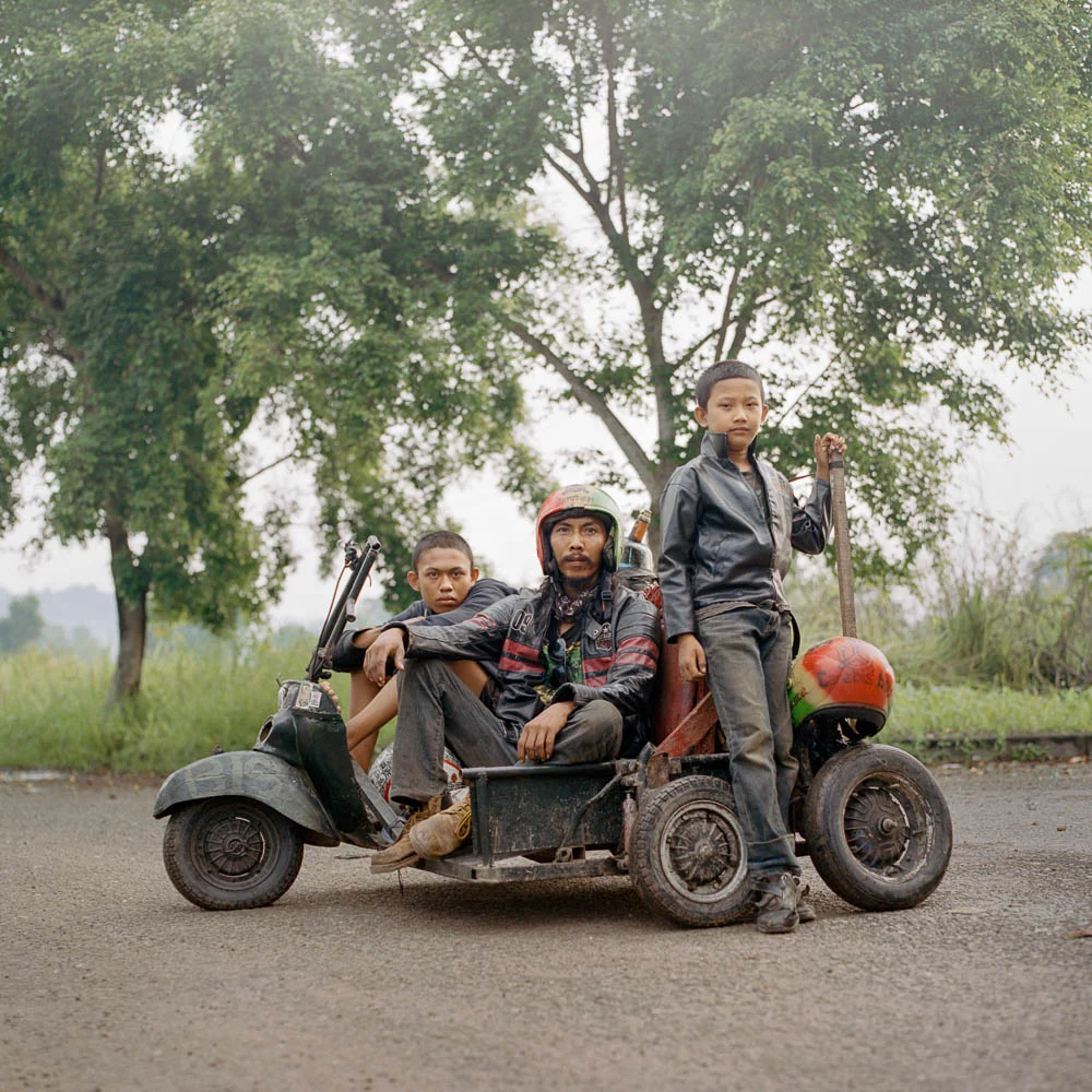 Iponk (middle), a scooterist from South Sumatra along with his son (right) and a travel companion (left). He traveled for hundreds of kilometers, mostly at night to avoid police, to attend a Vespa event in Lampung.