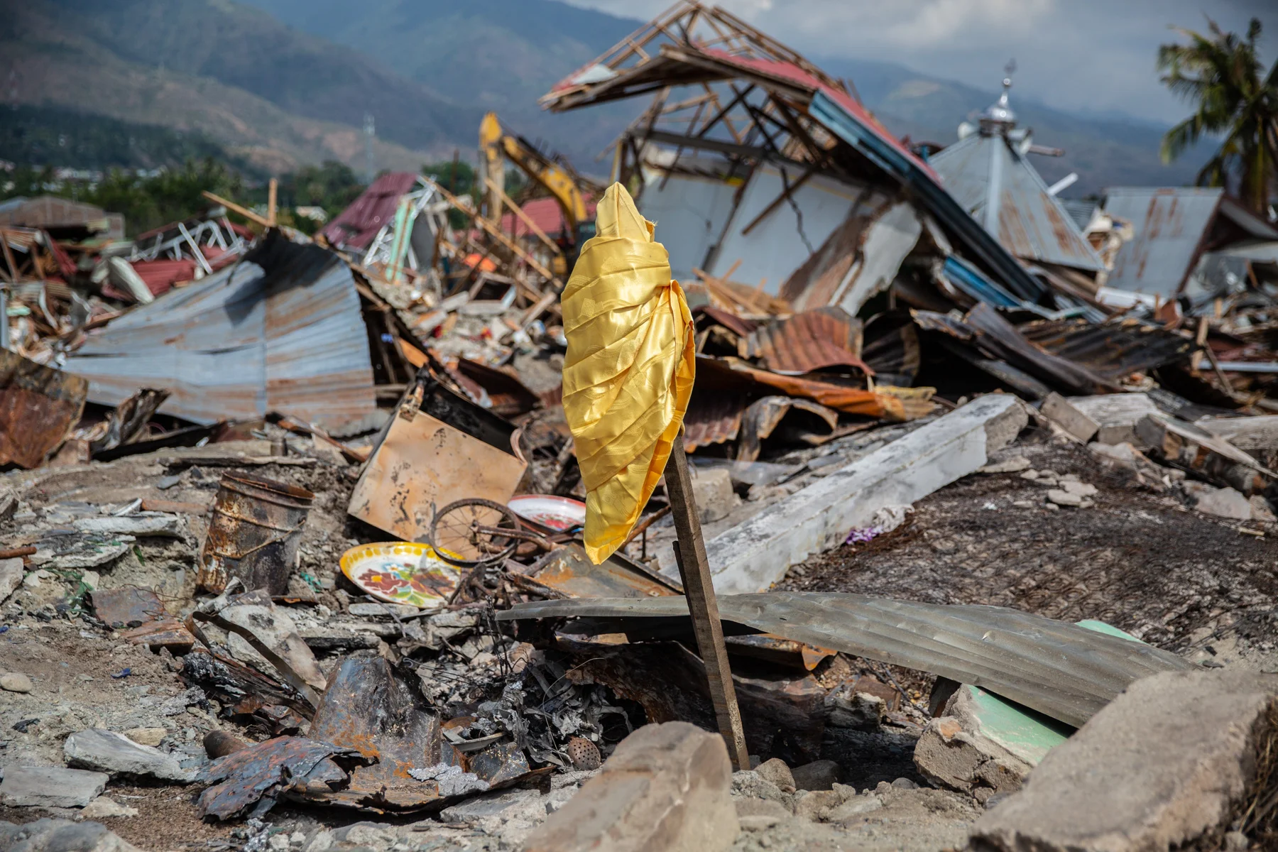A sign put on the ruins at Balaroa, Palu, Central Sulawesi. On Friday afternoon Sep. 28, 2018 Central Sulawesi hit by deadly earthquake that triggered tsunami and liquefaction that destroyed many places. Amid the ruins of Balaroa housing complex I met Huzaimah (38), one of the survivors of the disaster. Her eyes filled with tears as she told me how she could escape death. When the earthquake struck, a cupboard fell on her but luckily she was able to remove it, and then she immediately got out of the house. Sadly, her elder sister was lost amid the stumbling ground and had not been discovered when I met her. “That's why we put a sign there (pointing to the flag placed on the ruins) in the hope to find my sister even though she might have been dead”, she said. When I was walking around the area, I found some similar signs, signifying a hope that the search and rescue team would be able to find their relatives or loved ones. According to the national disaster mitigation agency death toll had risen to 2,113 with 1,309 still missing and the official search was stopped on last Friday, Oct 12, 2018.