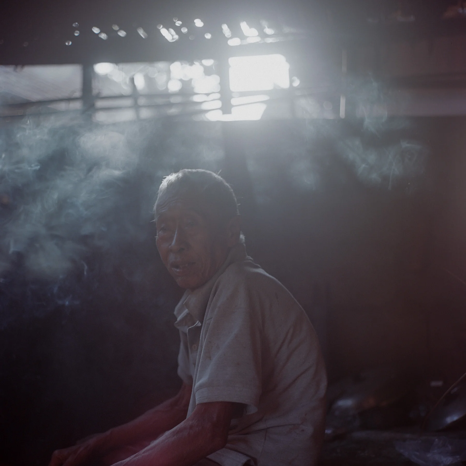 The late pekak keris poses for a portrait at his traditional kitchen at Tunjuk Village, Bali, Indonesia.