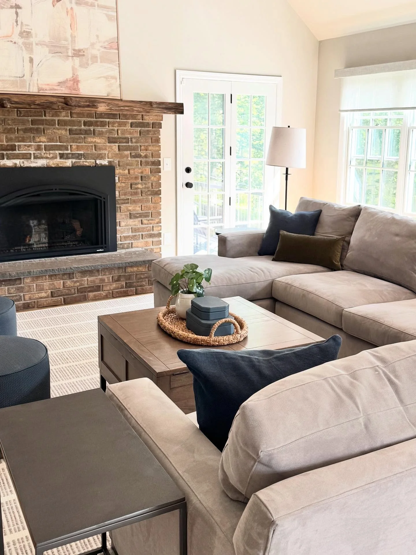 Fresh new take on this Family Room by using the existing foundation elements (sofa, coffee table, built-ins), the addition of neutral paint to wrap the space, expansive rug to unify the large room and pops of color in pillows and artwork to create a 