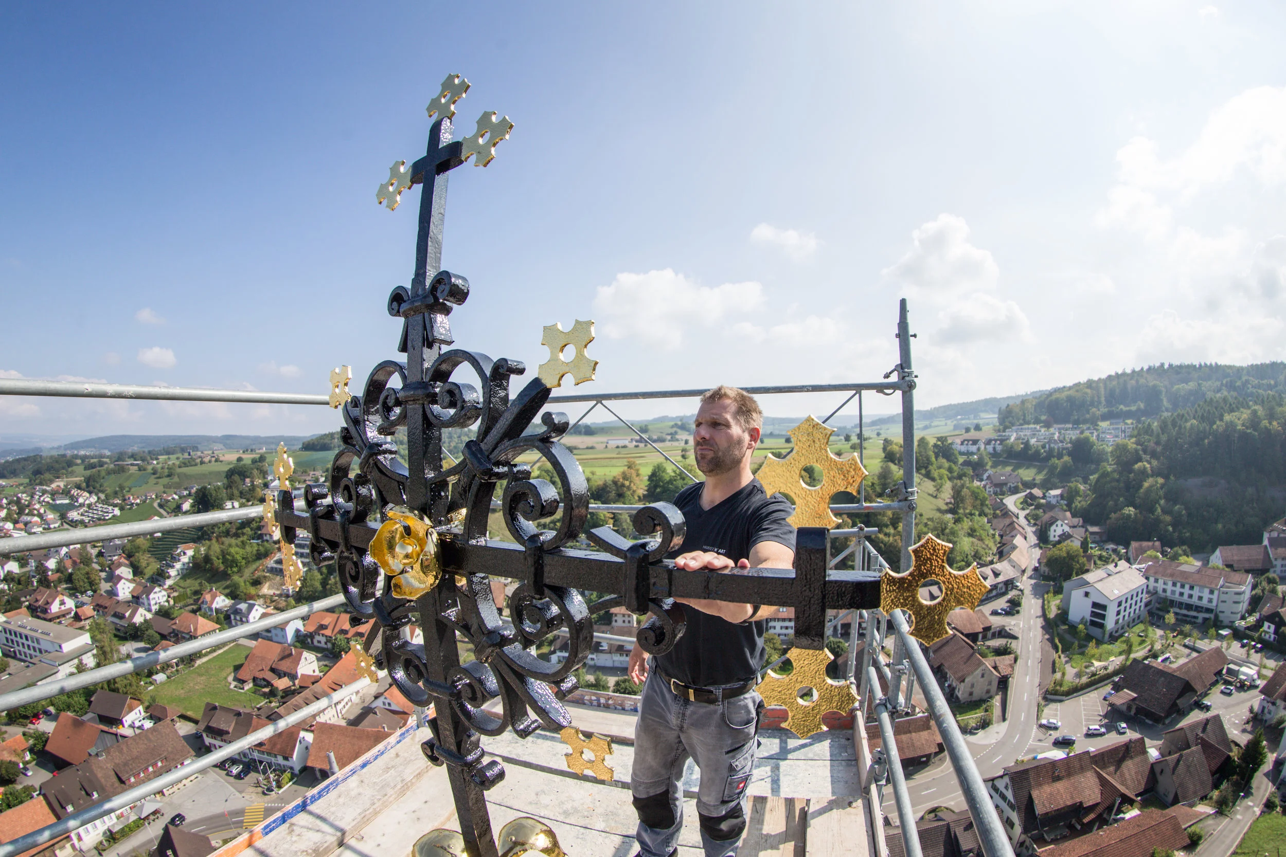 Ein Arbeiter überprüft das montierte Turmkreuz der katholischen Kirche in Würenlingen auf allfällige Kratzer und Schäden. Dabei wurde das Kreuz per Helikopter auf das Dach gehoben. (3. September 2018)