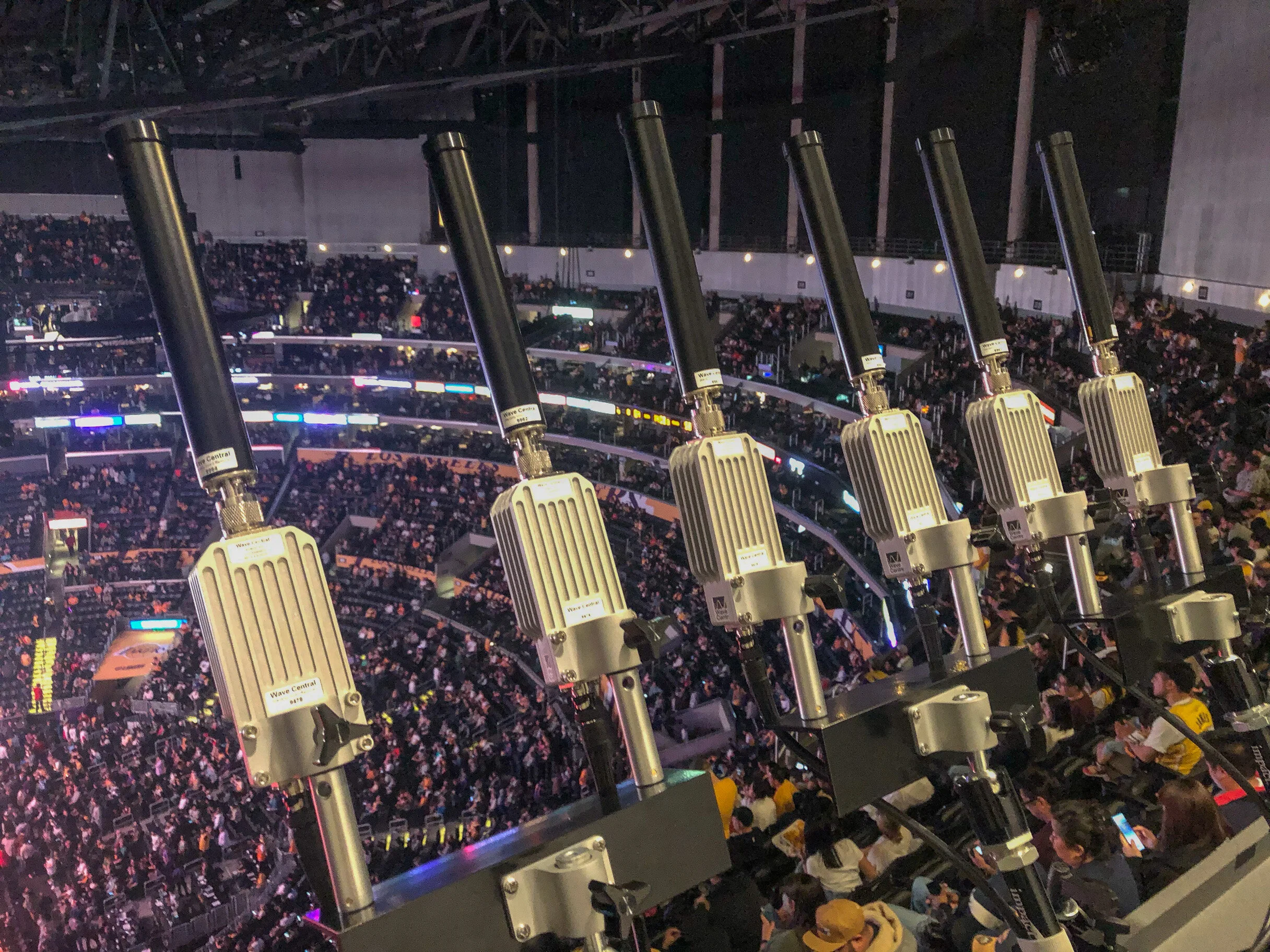 Image of six block down converters with sectional antennae above a crowded sports arena