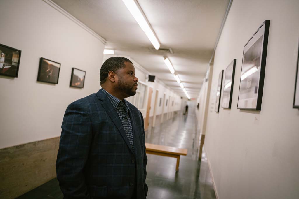 Workshop student Christopher Shurn looks at his photograph hung on the wall in the Hall of Justice for the first time.