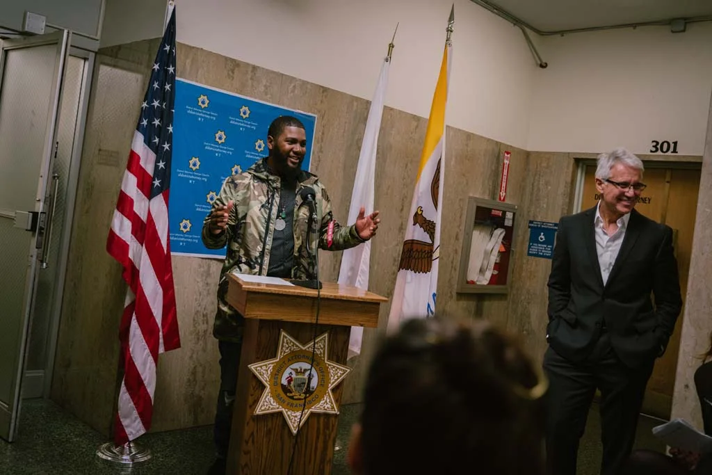 Workshop student Eugene Riley speaks during the opening reception of Visions of Justice alongside San Francisco District Attorney George Gascón at the Hall of Justice.