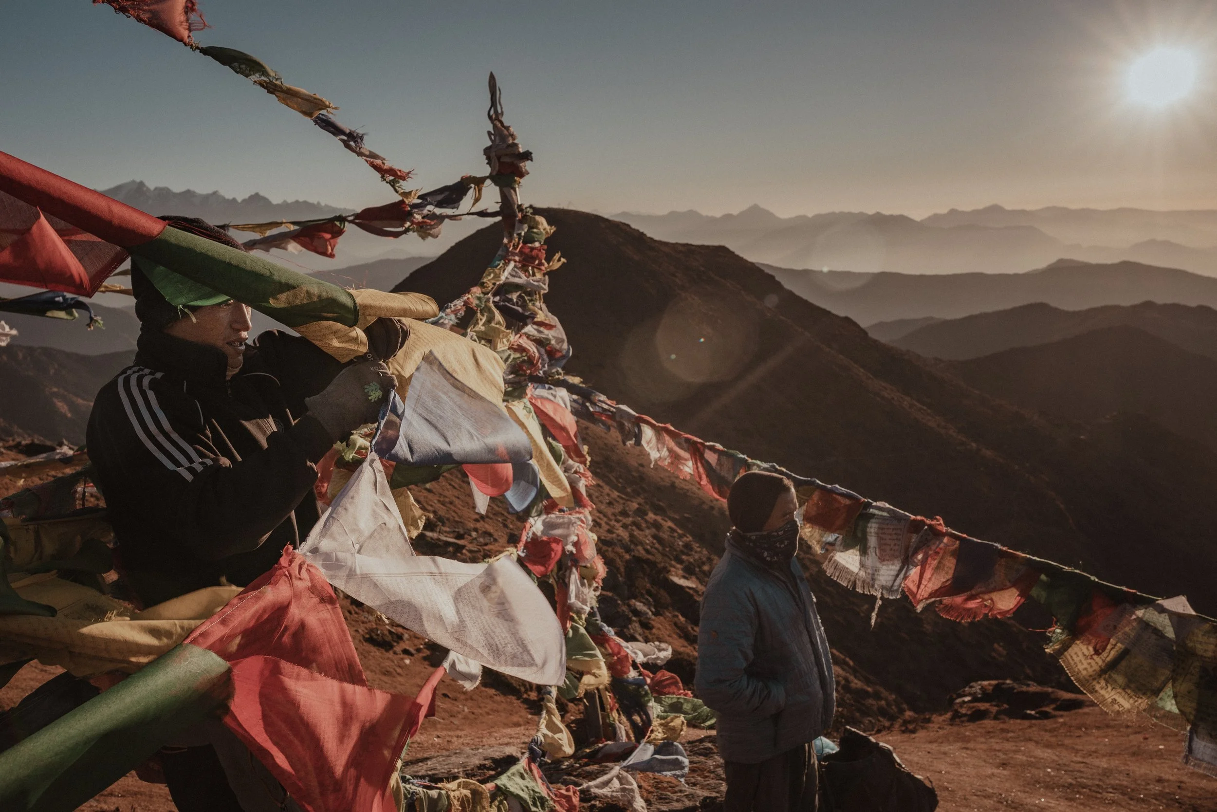 Stringing Buddhist prayer Flags at Pikay Peak - the only peak on Earth with a view of 8 of the world's 10 tallest mountains