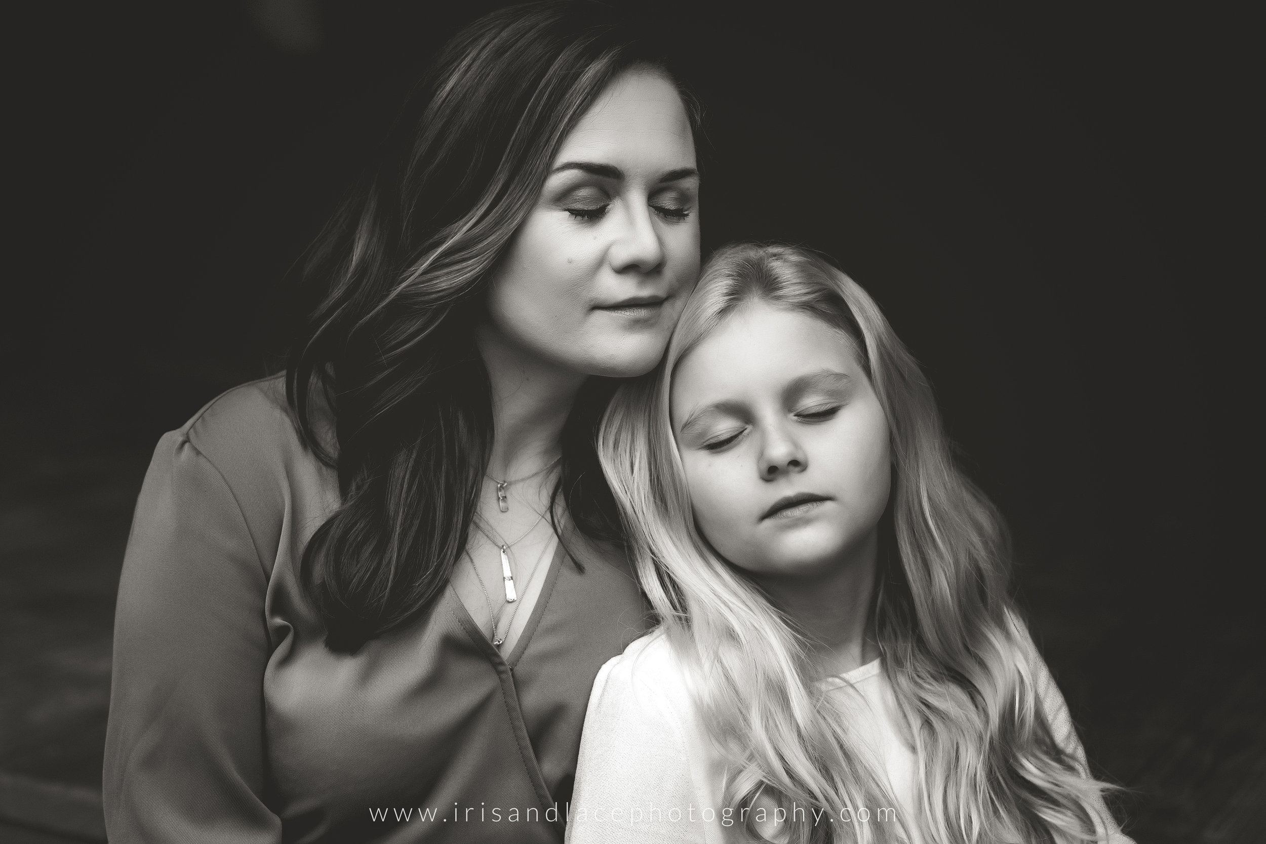 Mom and daughter closing eyes, snuggling