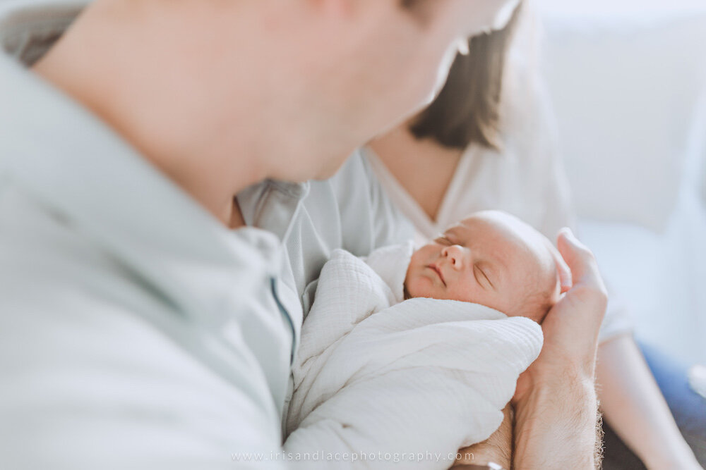 Father holding sleeping son Newborn lifestyle photography session