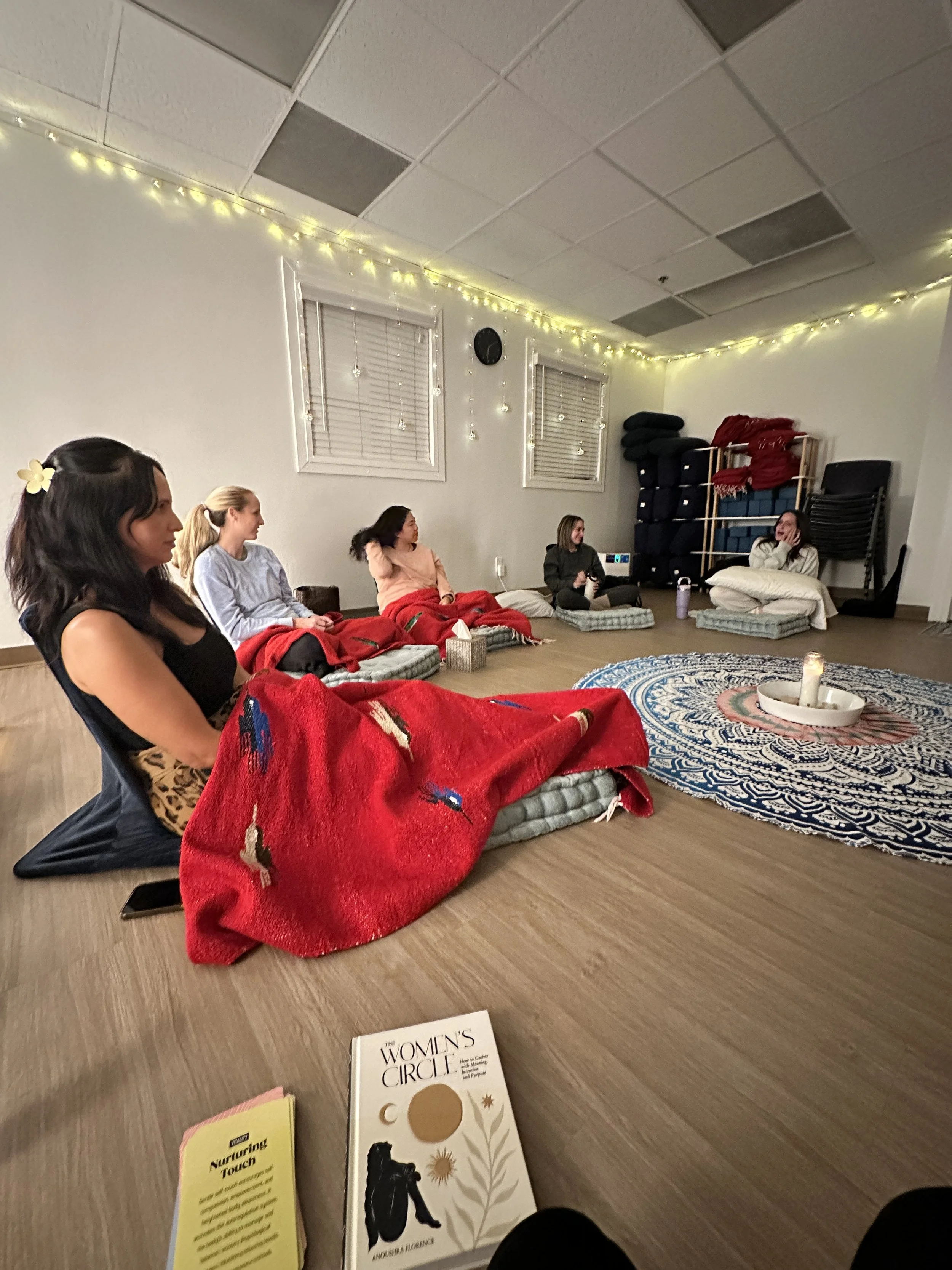 Group of women sitting on floor in a circle talking