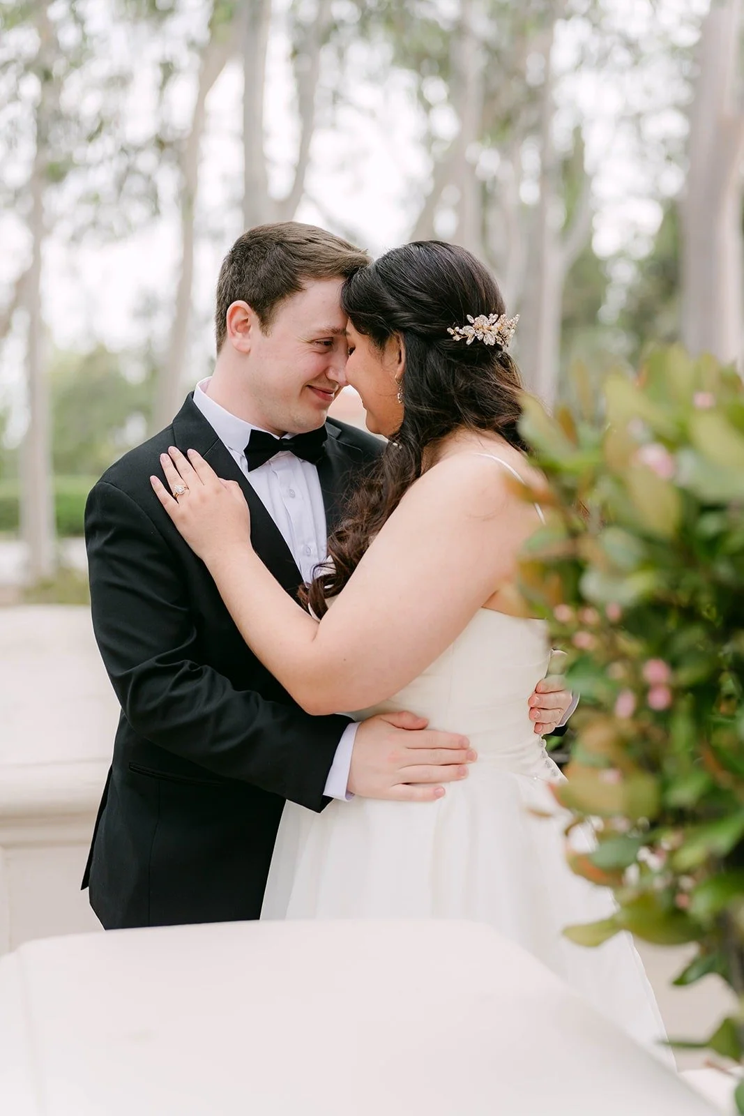 Saira and Matthew touching foreheads under the trees on the Caltech campus