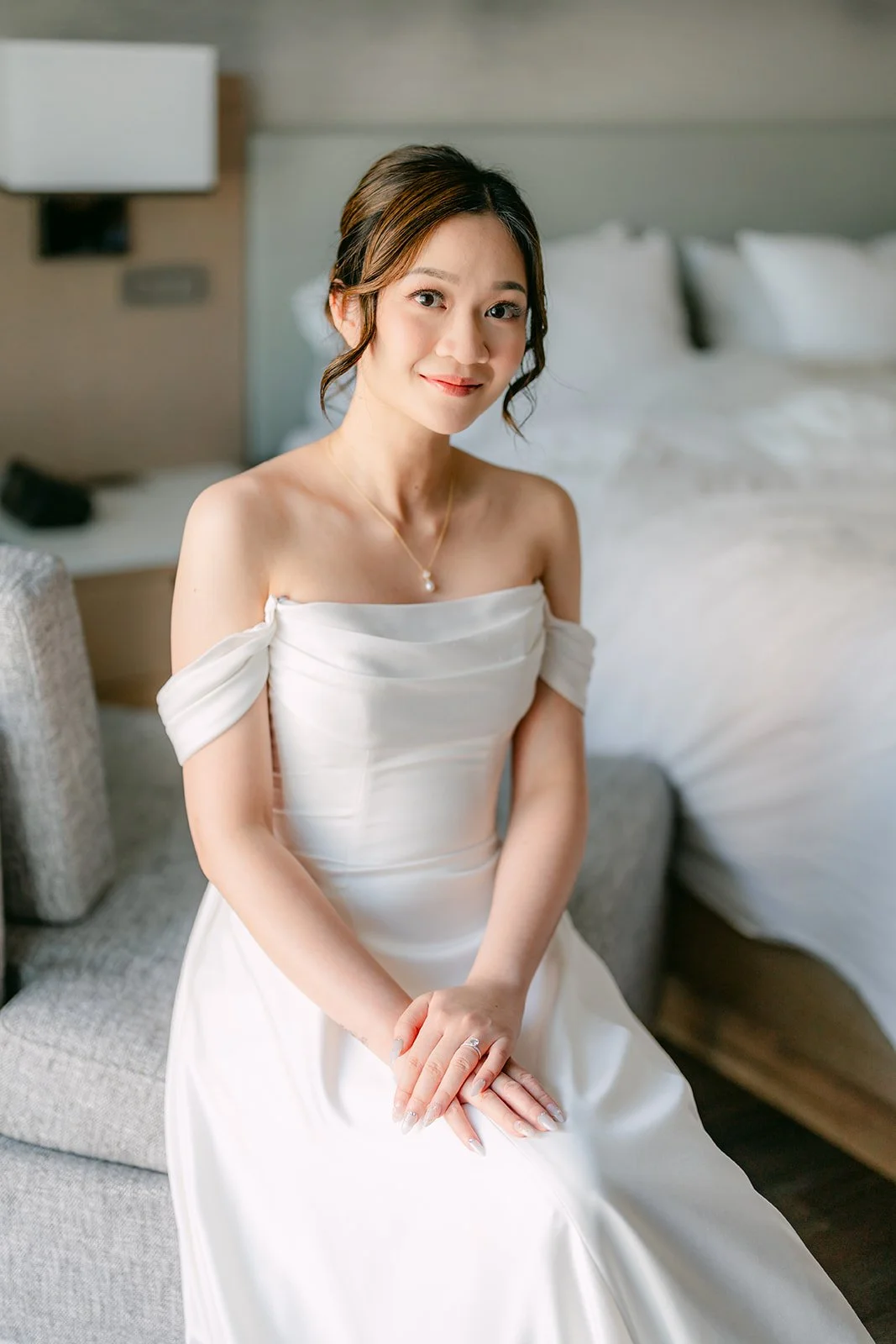 Amanda sitting on the edge of the bed in her wedding gown.