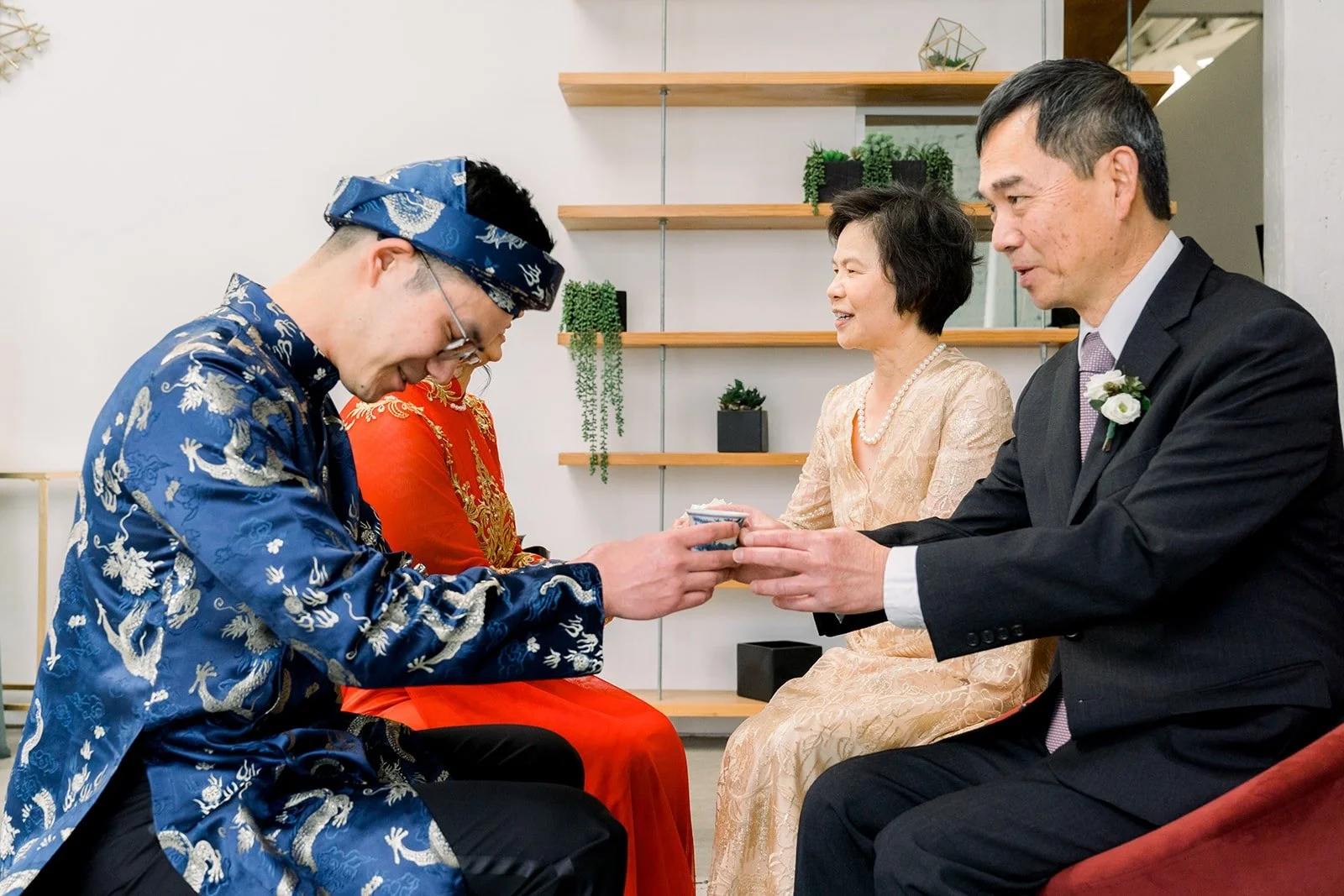 A family member receives tea from Alex and Cindy