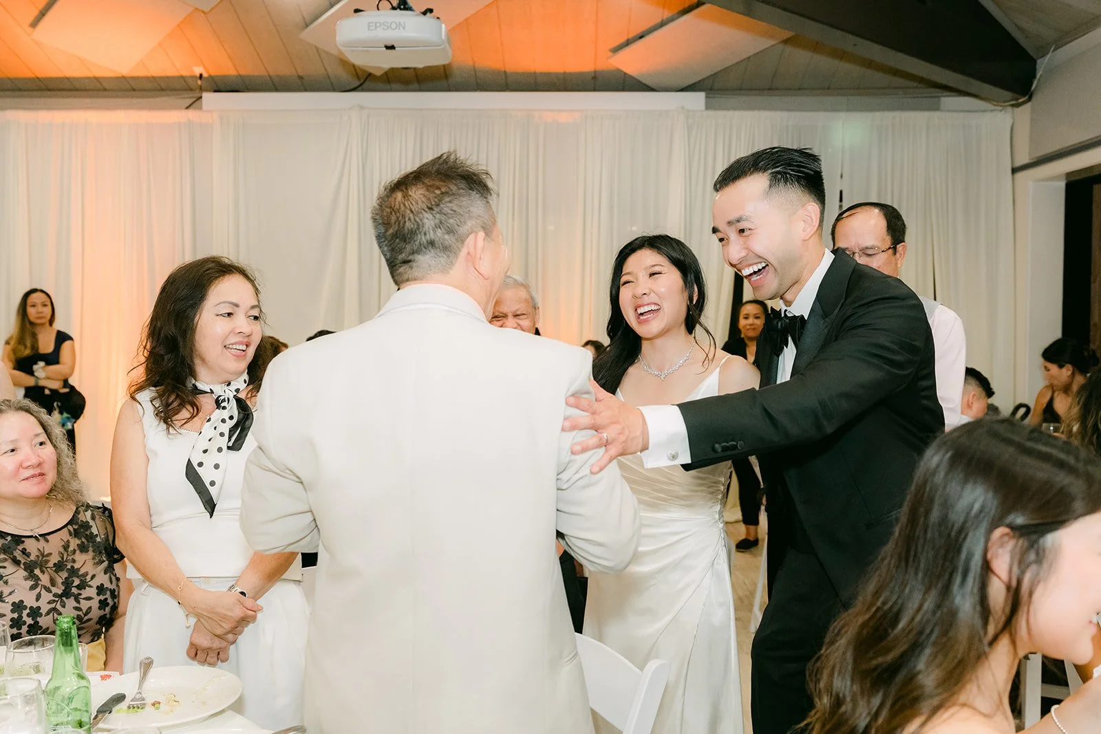 Kim and Vincent toasting with a table of guests