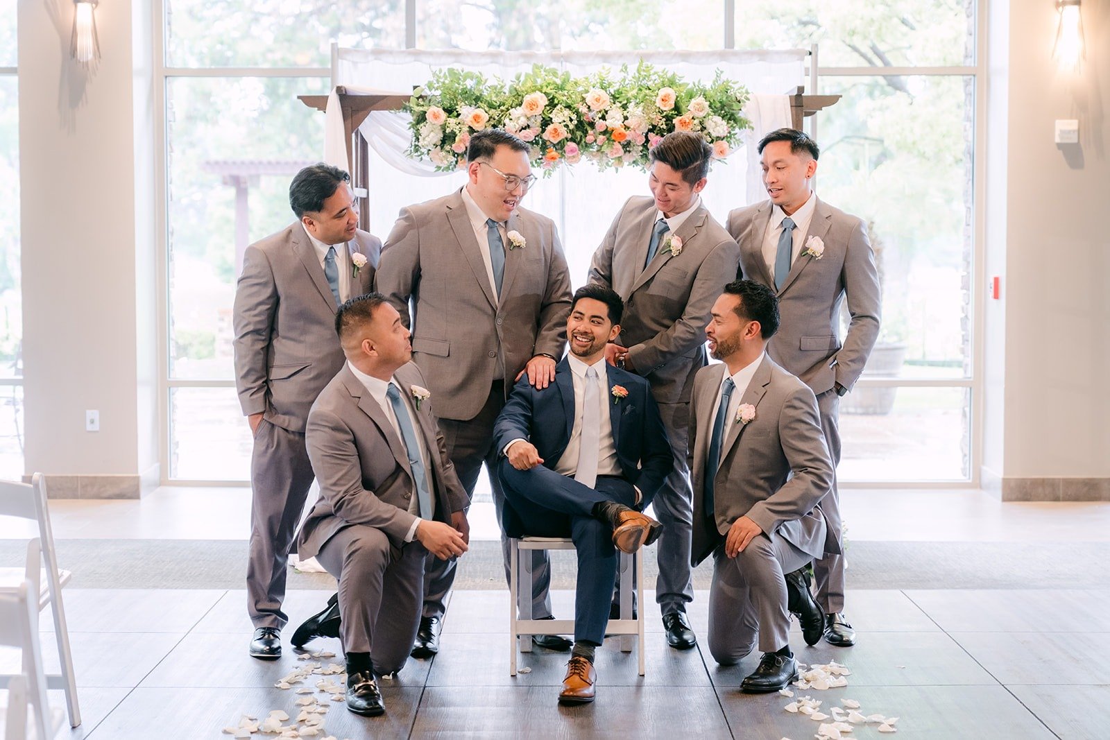 Mark and his groomsmen in a relaxed group pose at the ceremony arch, photographed by One and Only Production