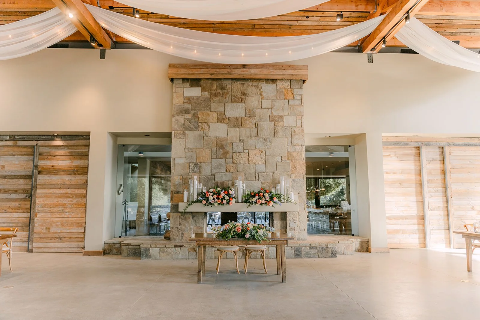 Reception hall with a stone fireplace and draped ceiling