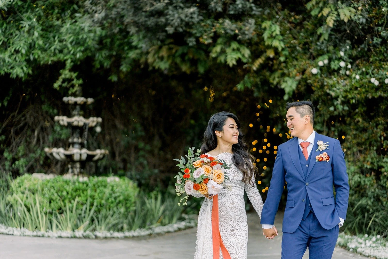 Hannah and Vincent holding hands by the fountain