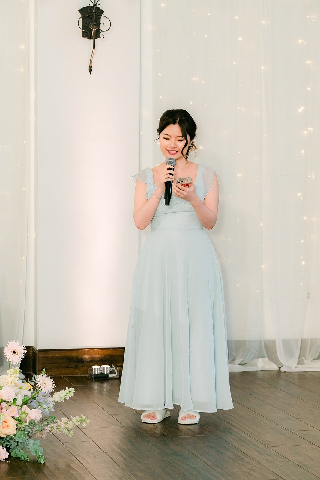 A bridesmaid in dusty blue sharing her speech