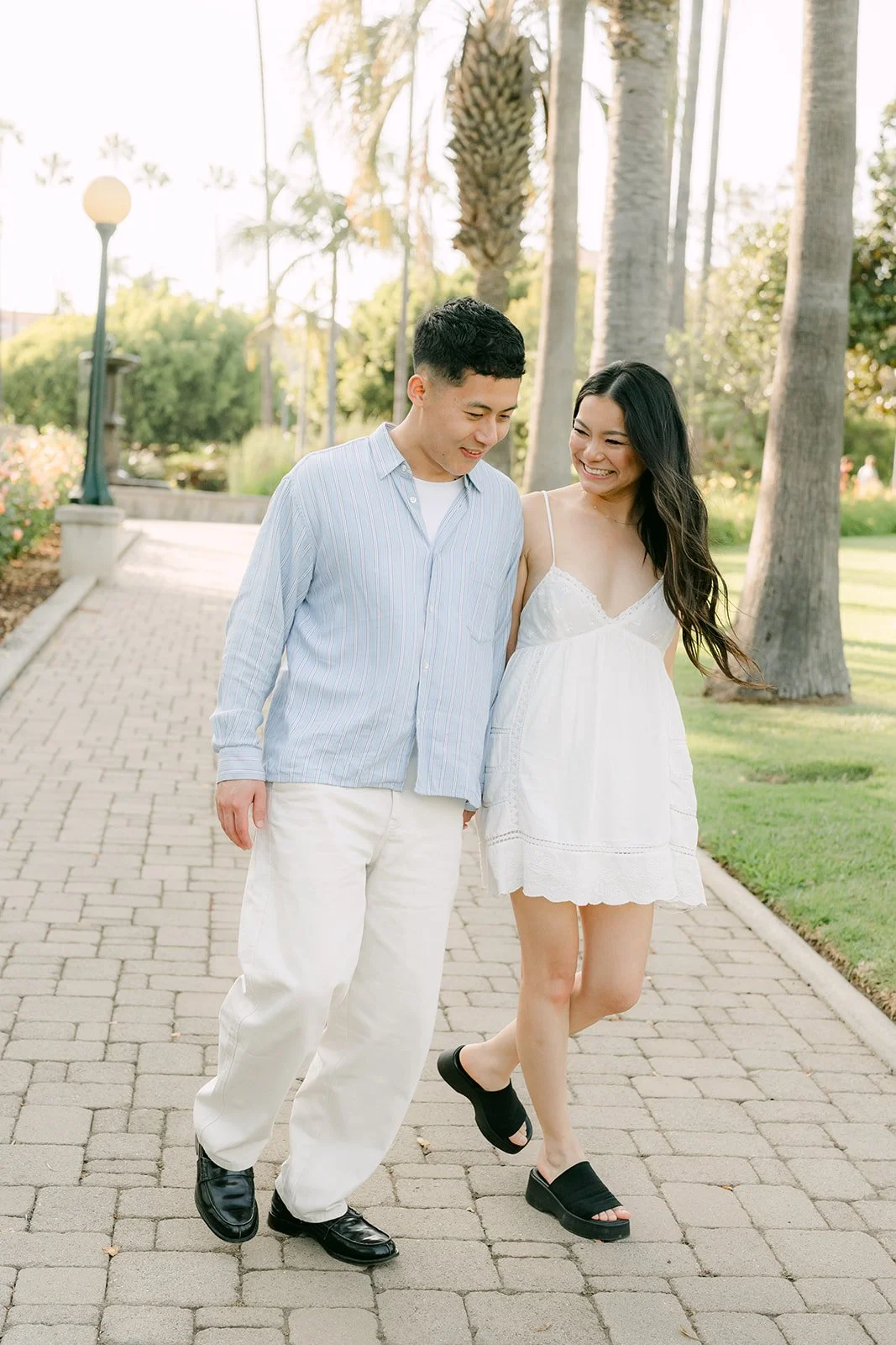 Jadee and Richard walk hand in hand along the brick path.