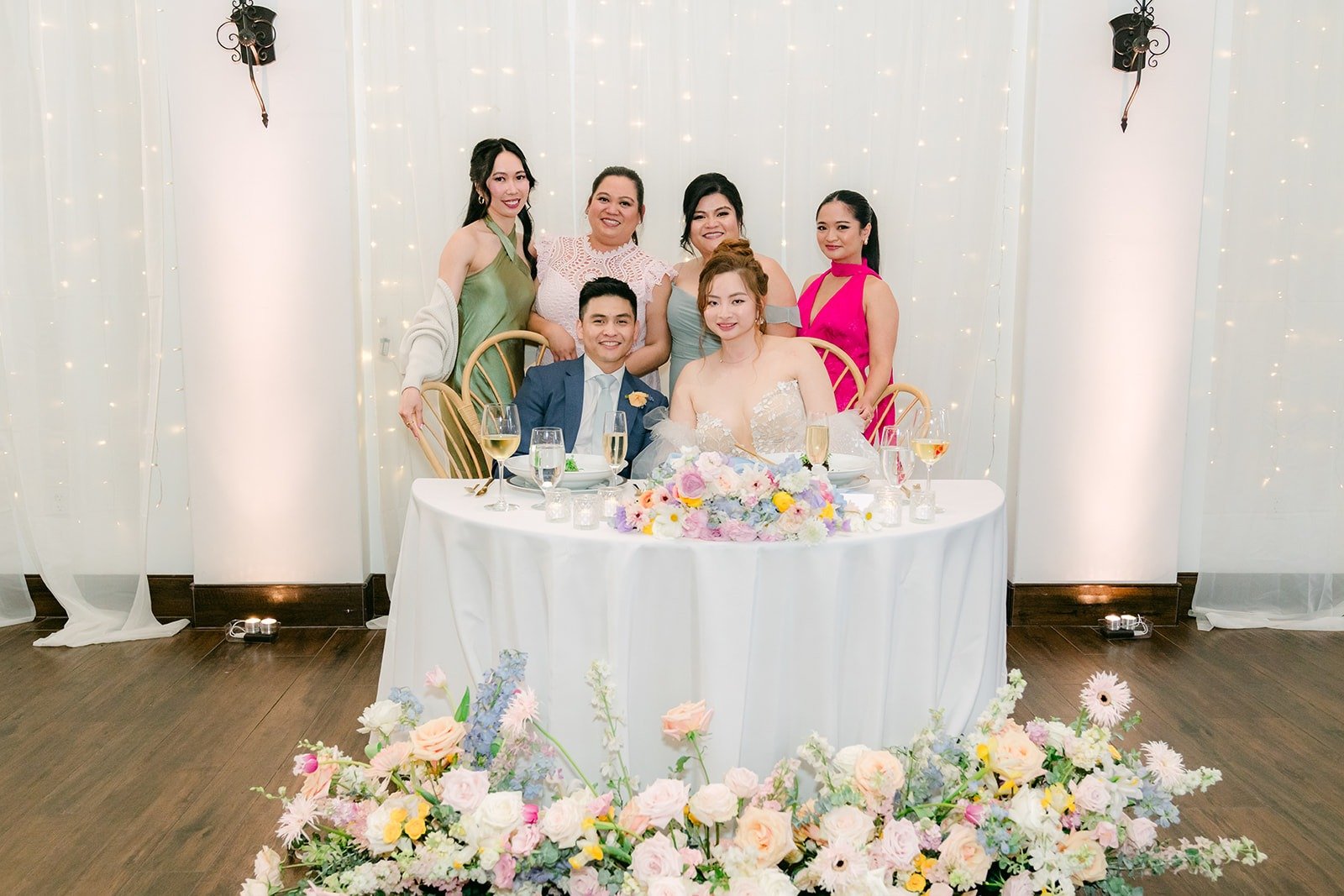 Joanna and Jerrick with friends behind the sweetheart table, photographed by One and Only Production