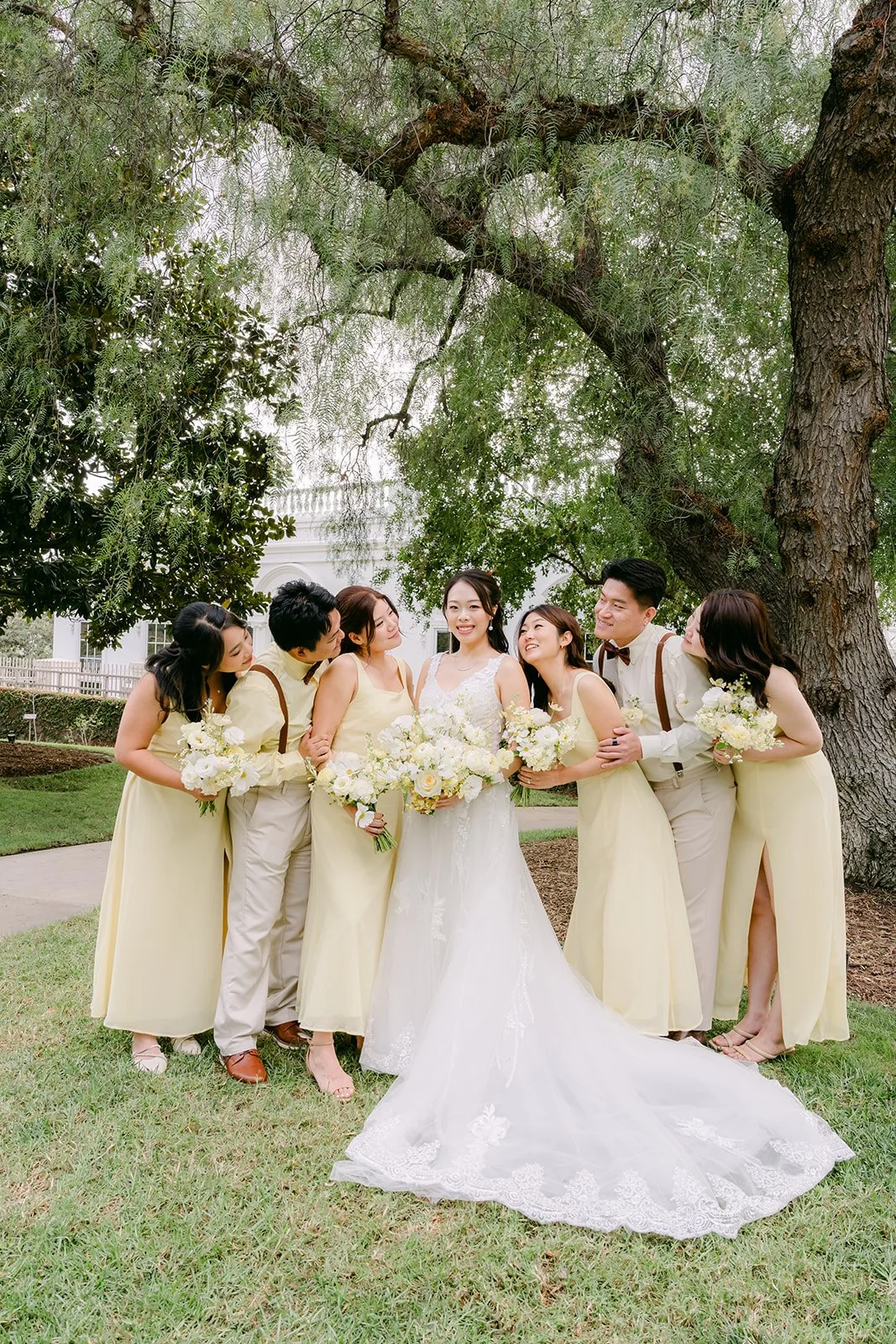 Bridesmaids gathered around Jenny under a big tree.