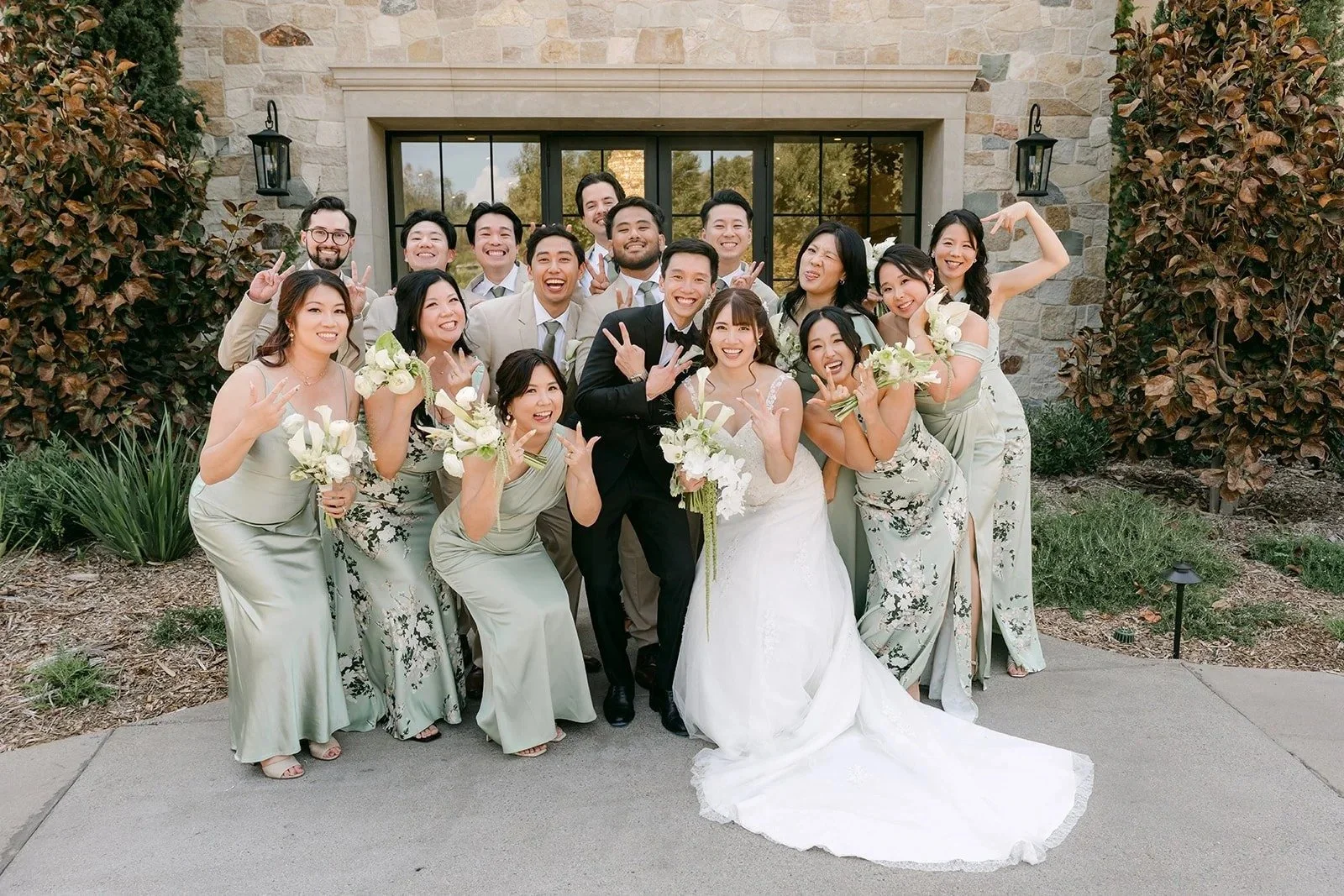 Wedding party in sage and tan cheering around the bride and groom