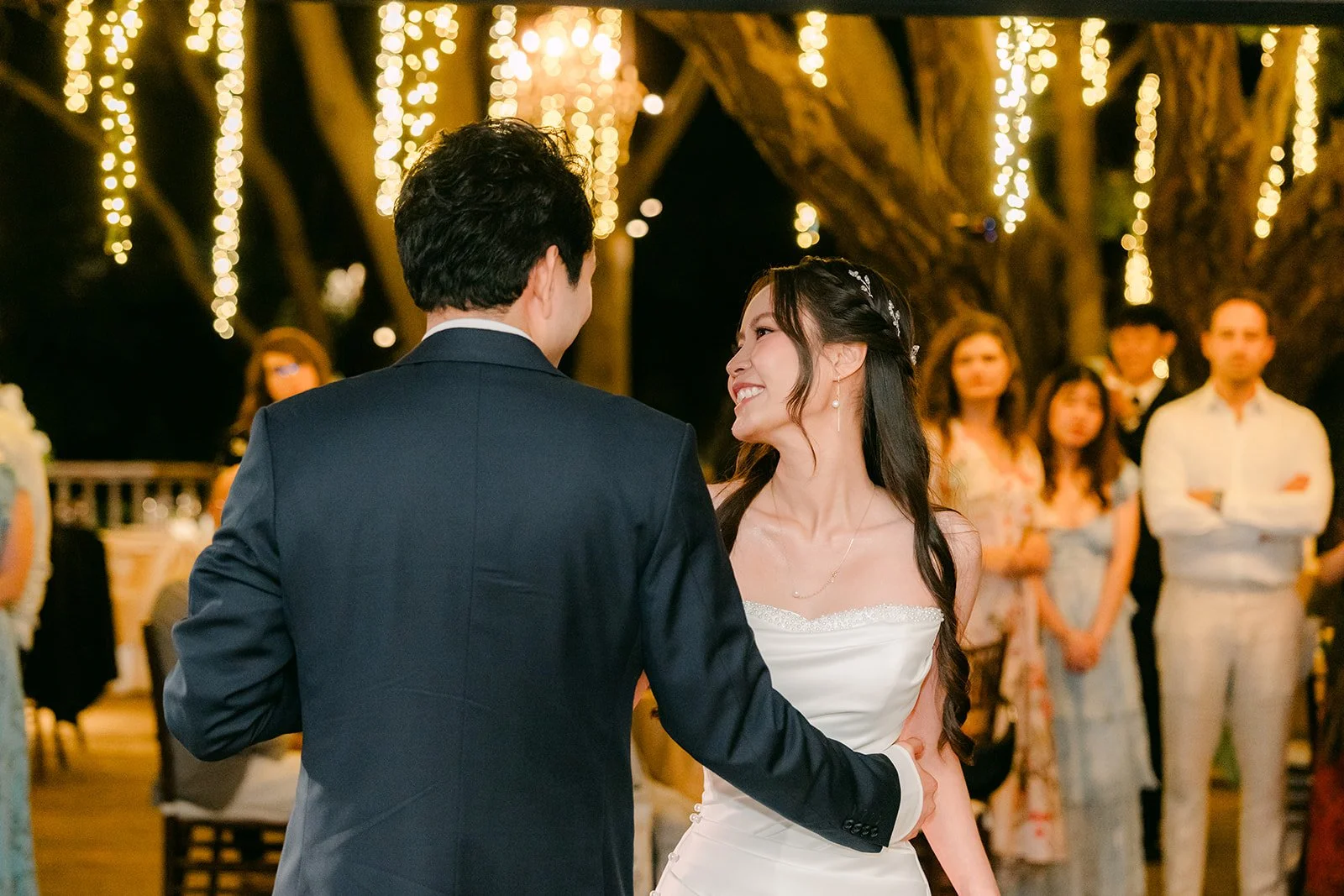 Nhi beaming at Shogo during the first dance as guests watch