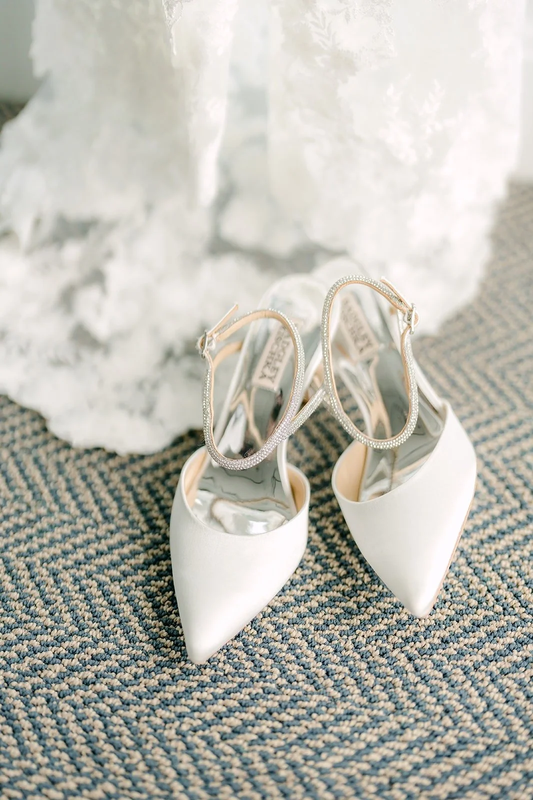 Angela's ivory heels resting on the lace train of her gown