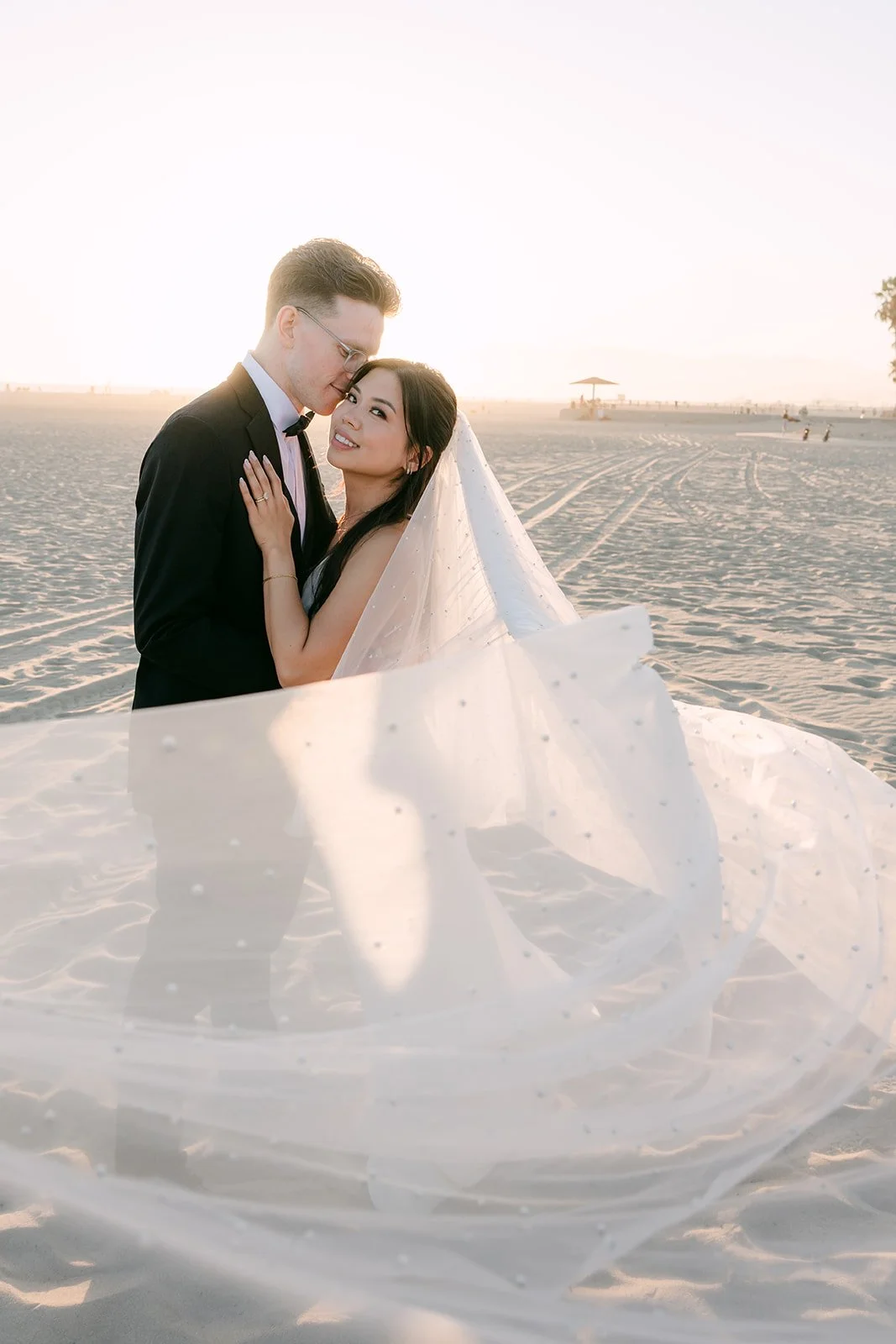 Justine and Matthew embracing on the sand