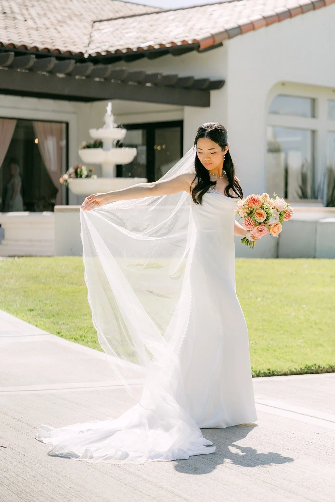 Stephanie spreading her long veil on the walkway in front of the Sterling Hills fountain
