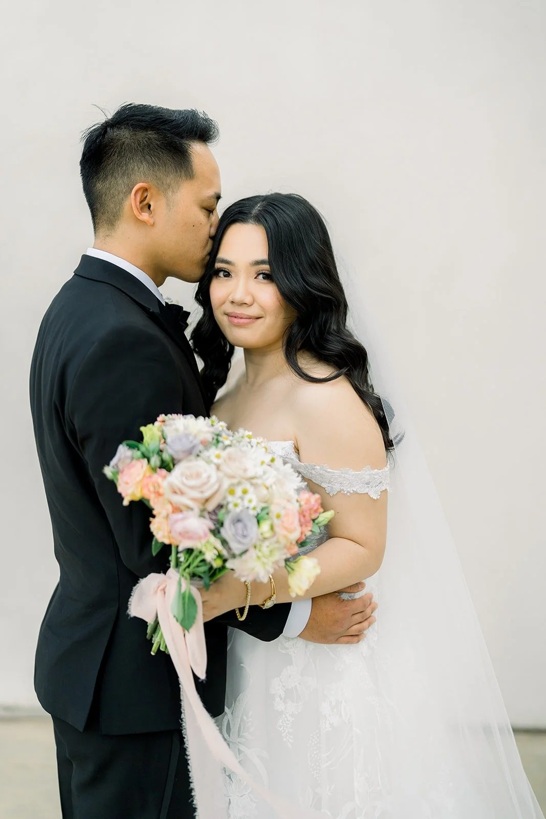 Ralph kissing Francesca's forehead as she holds her bouquet