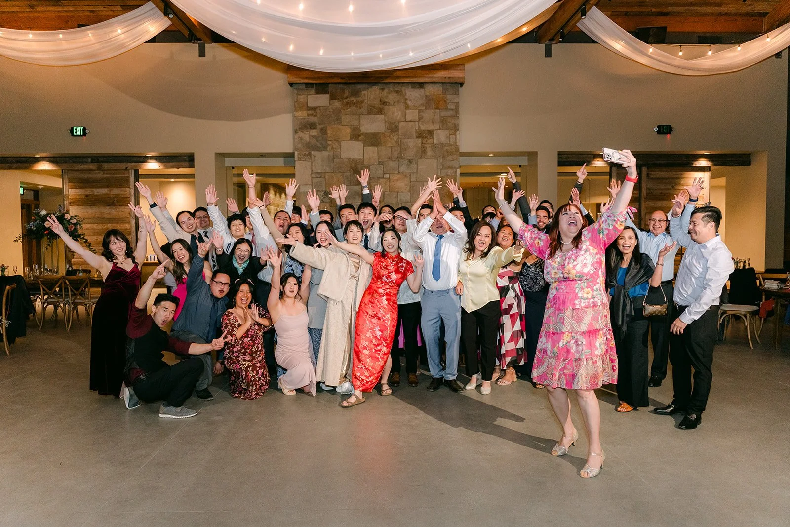 Group photo of all the wedding guests in the reception hall
