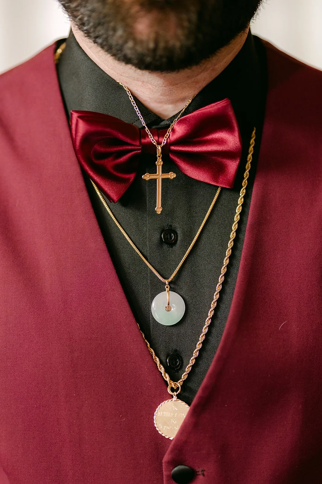 Close-up of Ryan's burgundy bow tie and necklaces.
