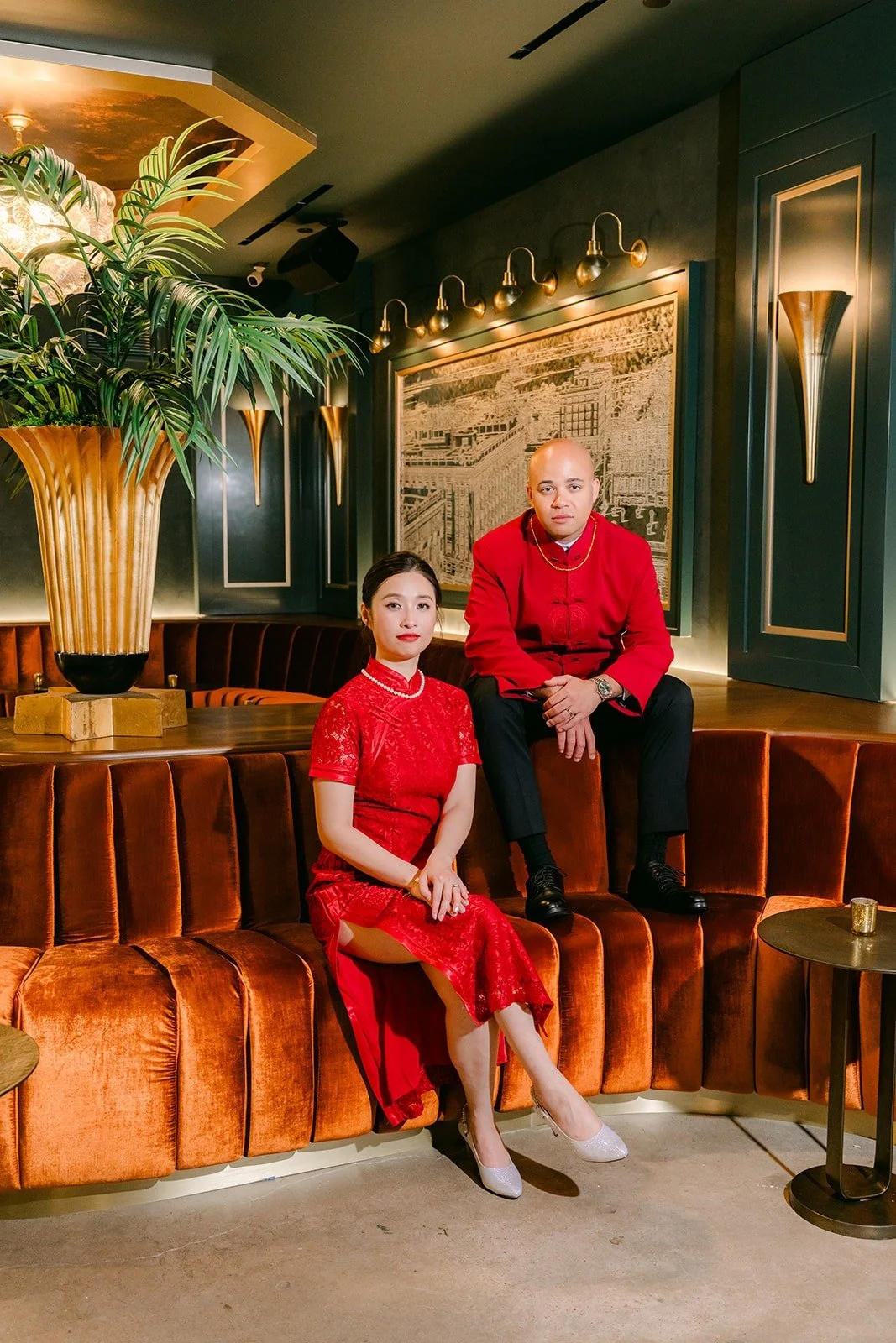 Elisa and Brandon in red on the orange velvet banquette in the lounge