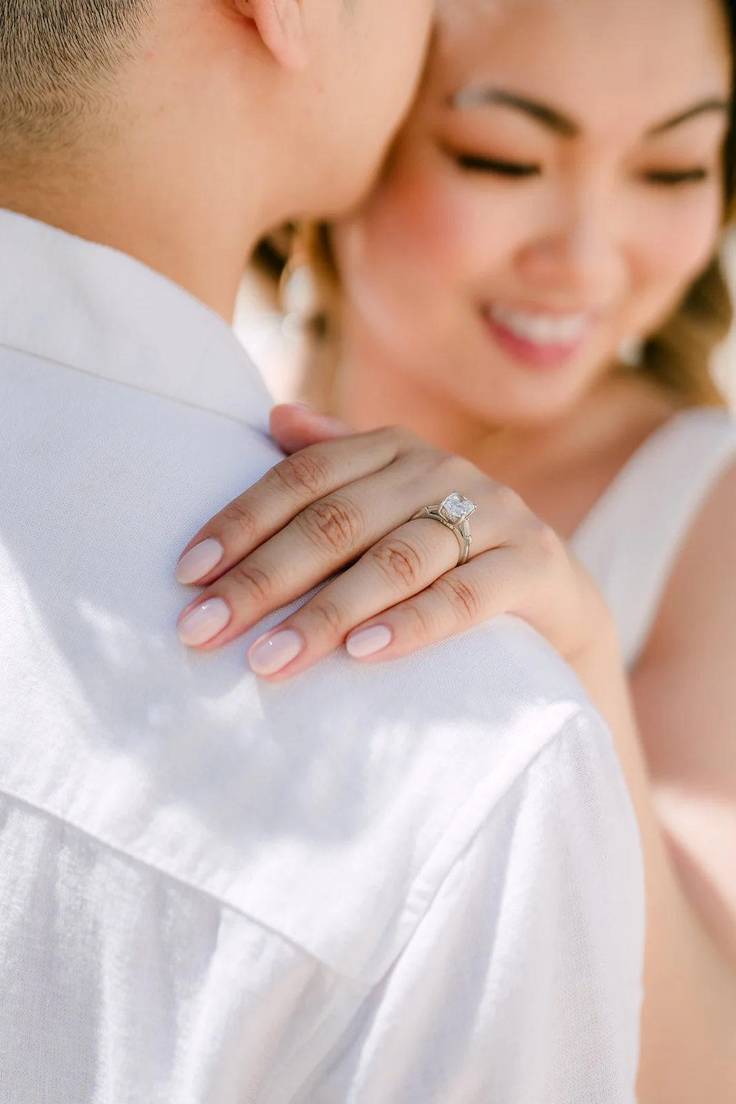 Stephanie rests her ring hand on Alan's shoulder.