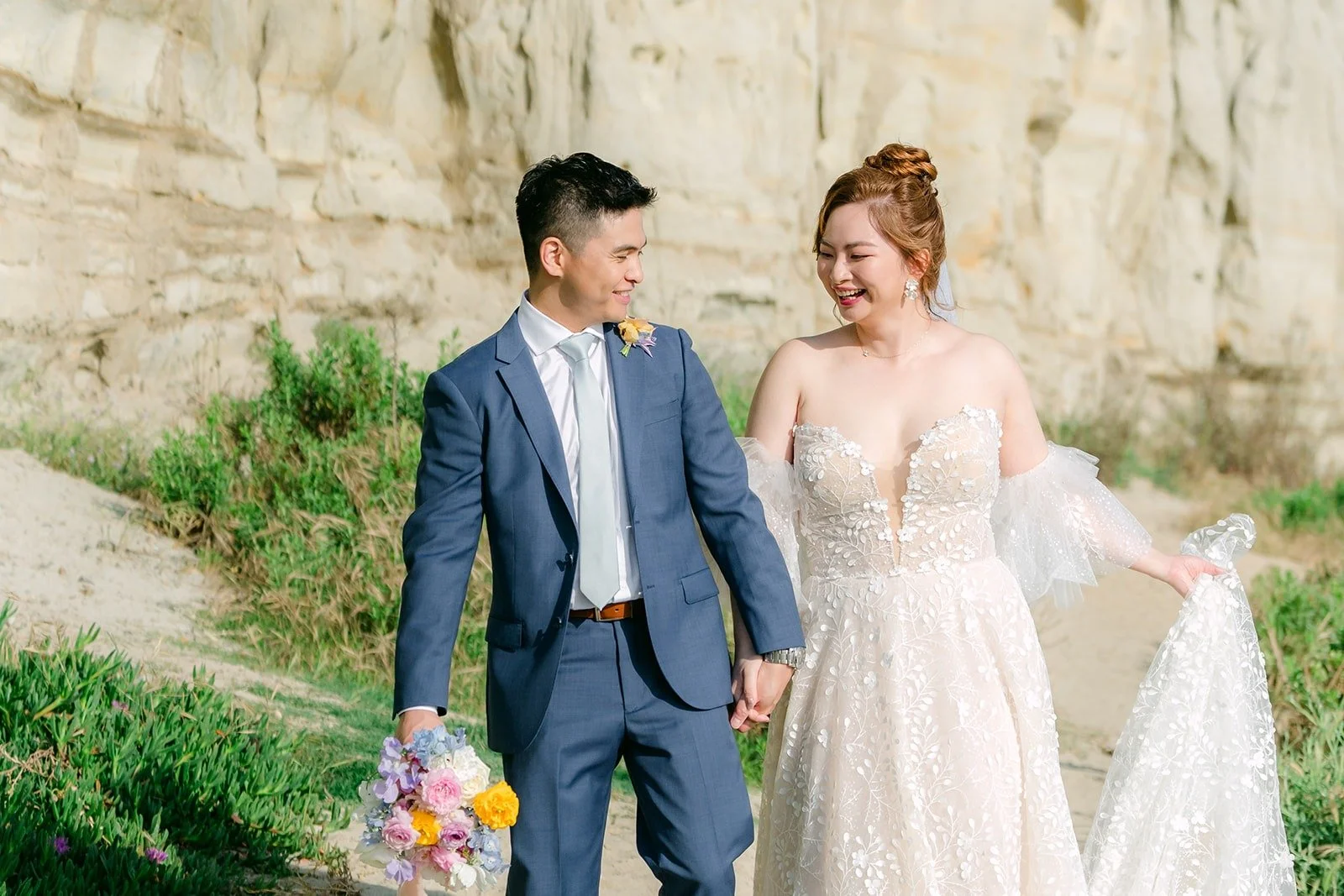 Joanna and Jerrick smiling together with the San Clemente cliffs behind them