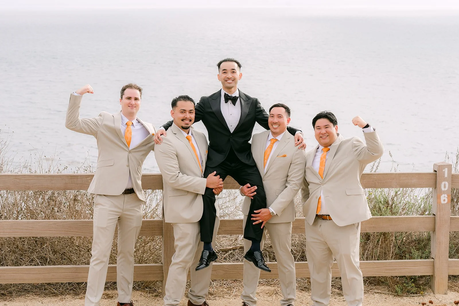Groomsmen lifting Vincent at the ocean overlook at Point Vicente
