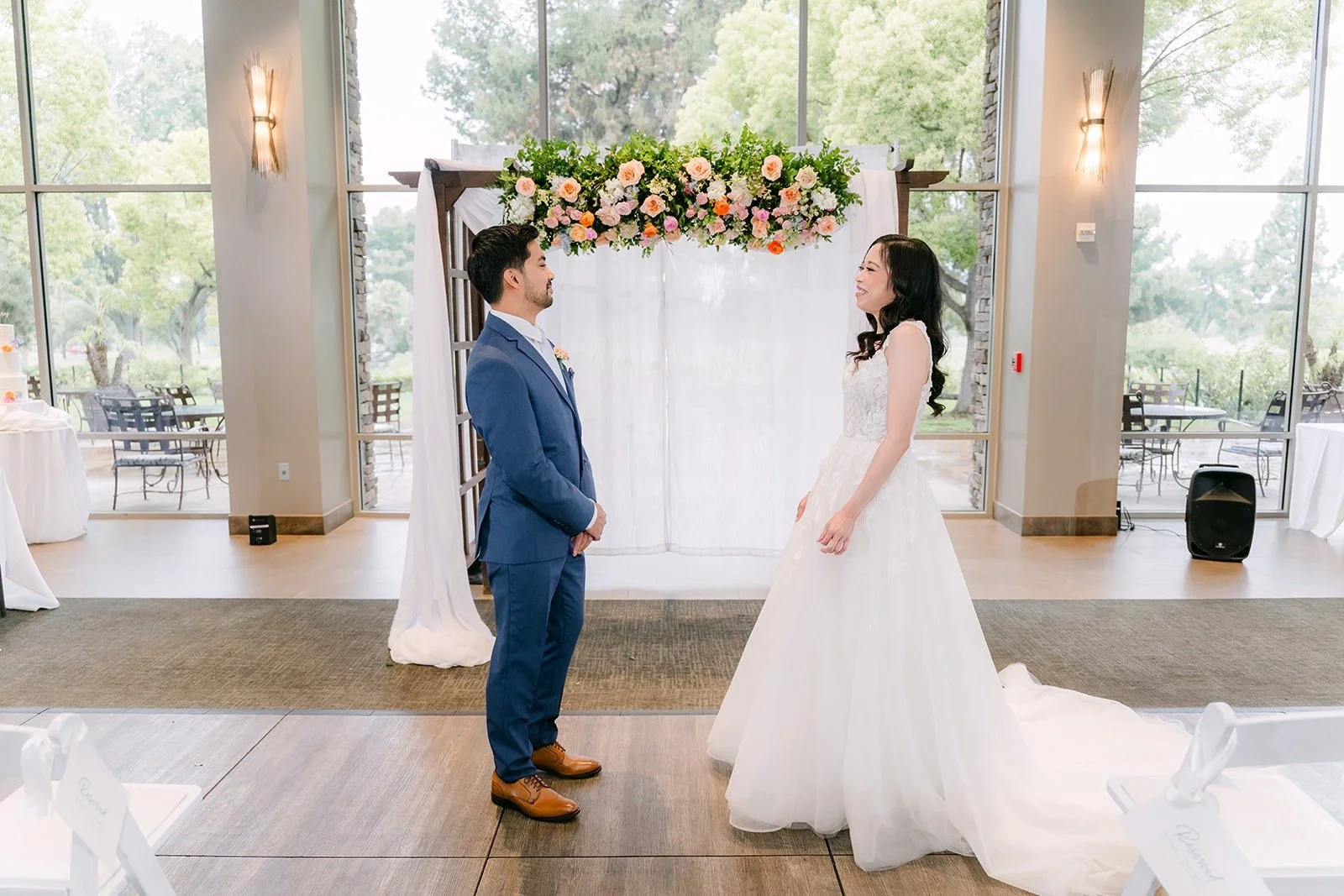 Natalie tapping Mark on the shoulder at the floral arch for their first look