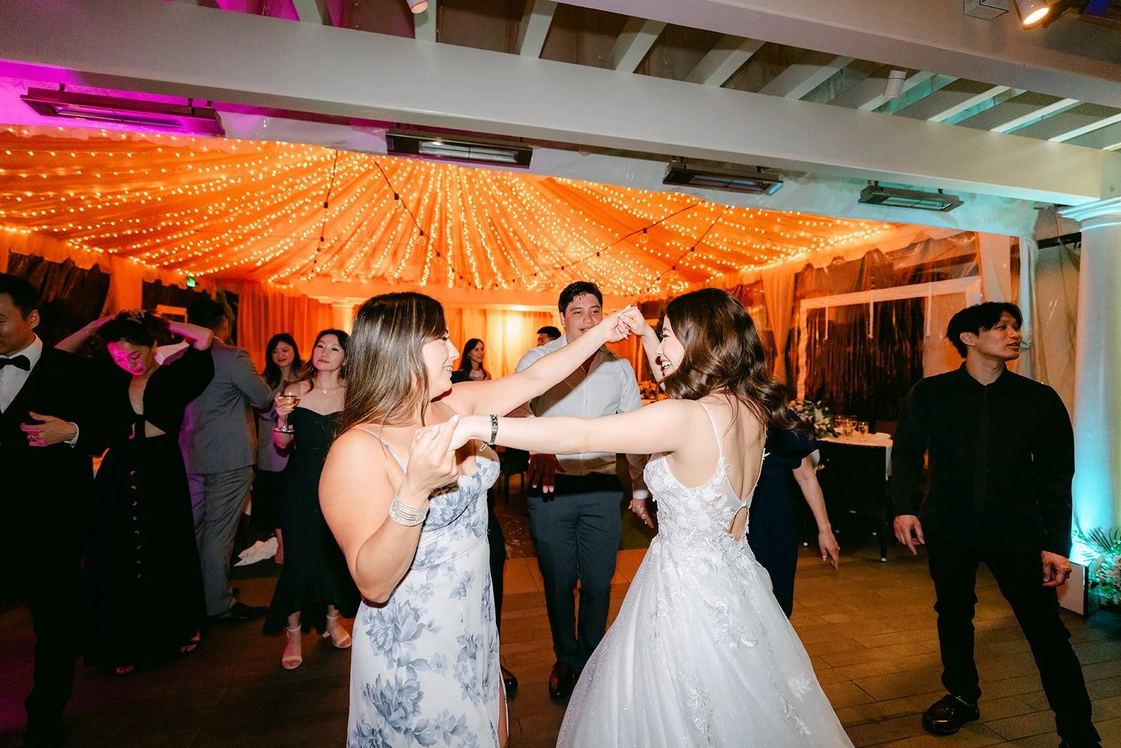 Valerie dancing with guests beneath the glowing canopy