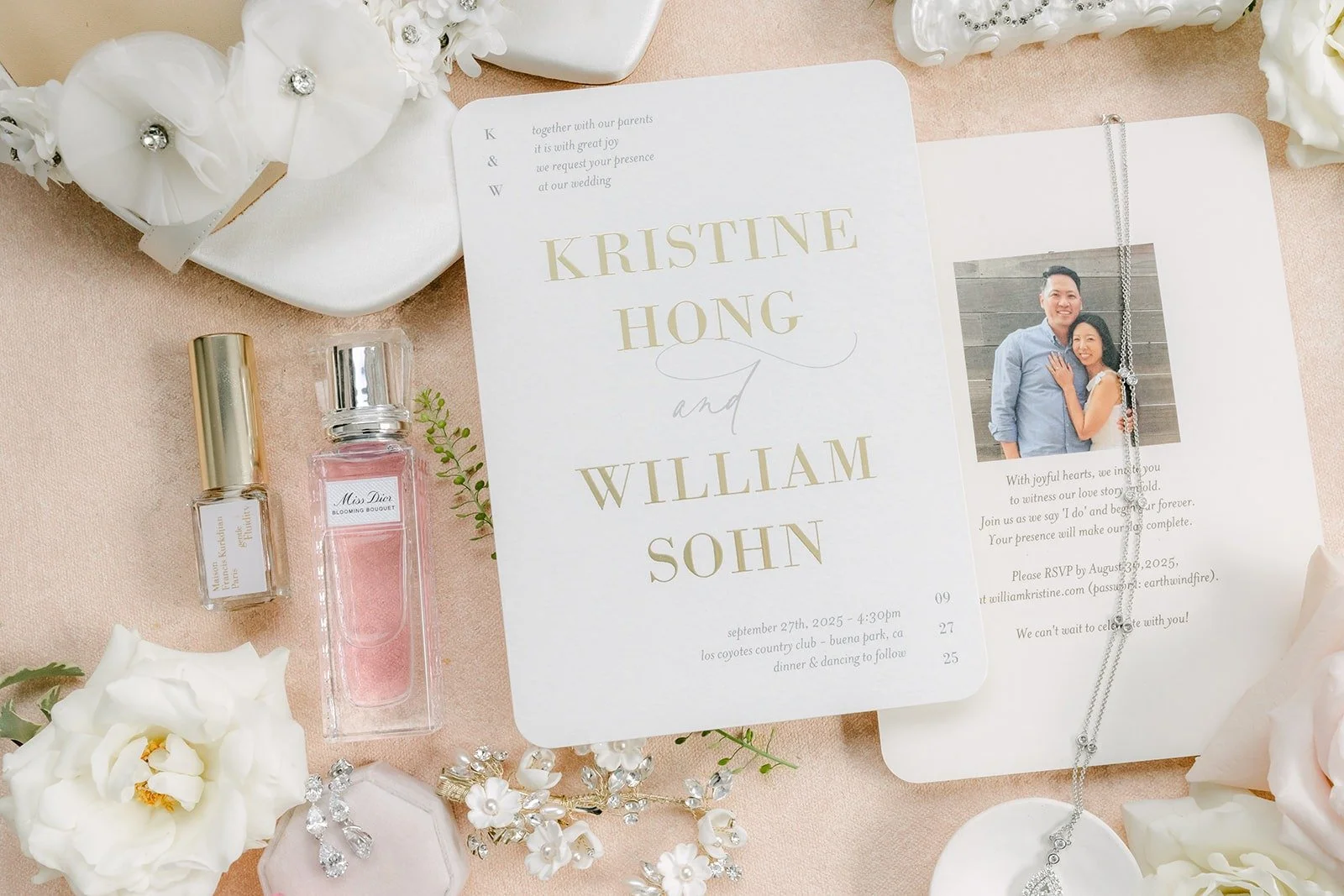 Kristine and William's wedding invitation styled with white roses, perfume and a ring box