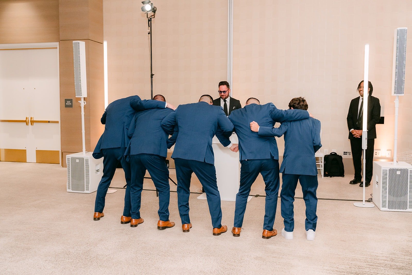 The groomsmen huddle up on the dance floor during their entrance
