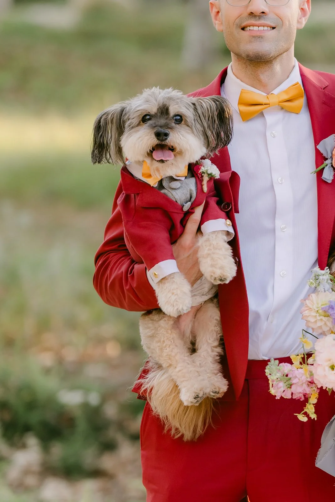 Izzo in his red outfit in Christian's arms.