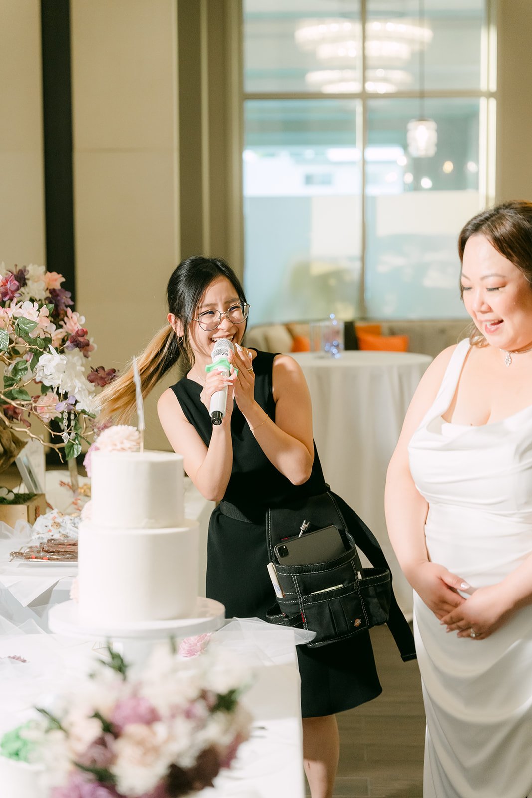 A guest filming the couple by the cake.