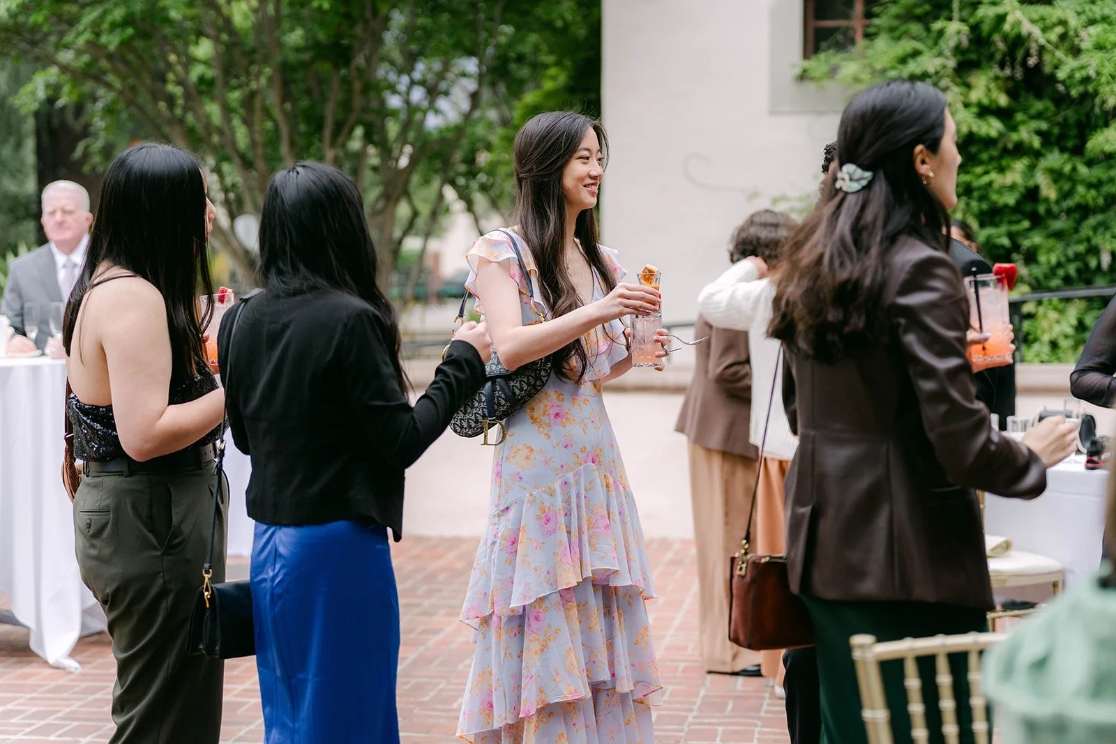 Guests mingling with drinks on the patio during the welcome hour