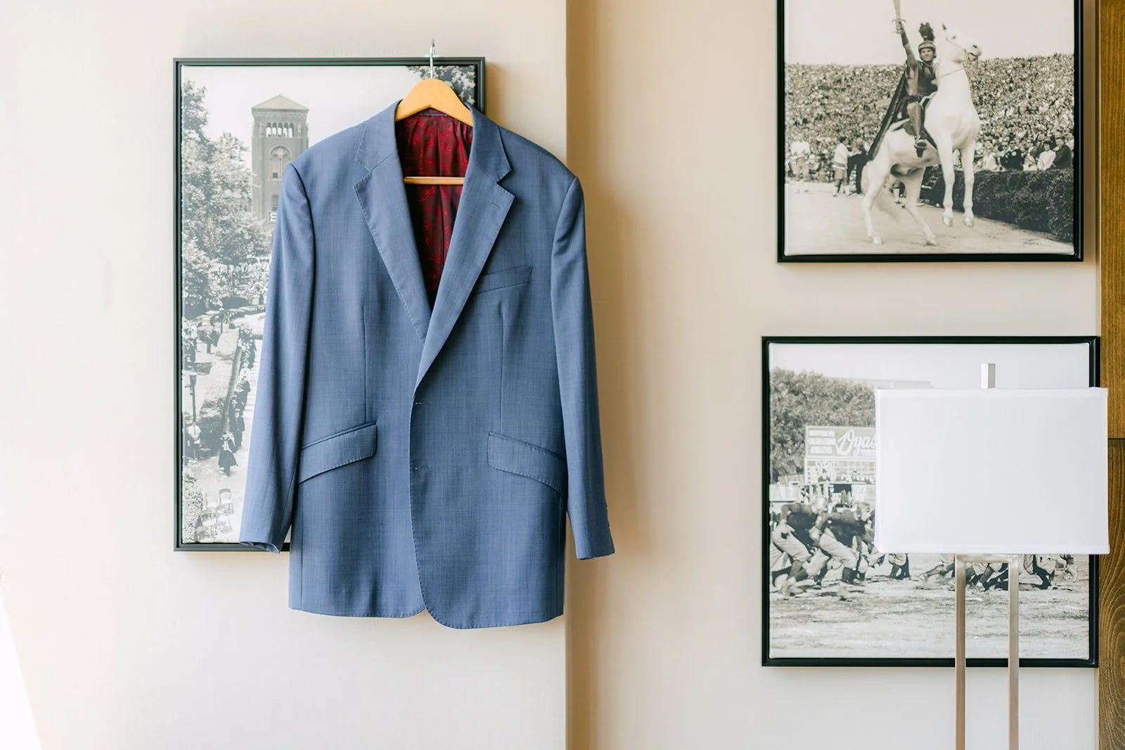 Philip's light blue suit hanging beside framed photos at the USC Hotel