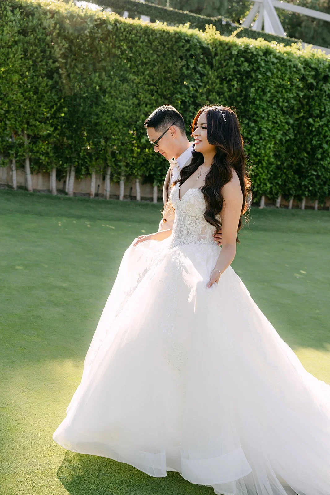 Kevin holding Sandra close in front of the hedge wall.