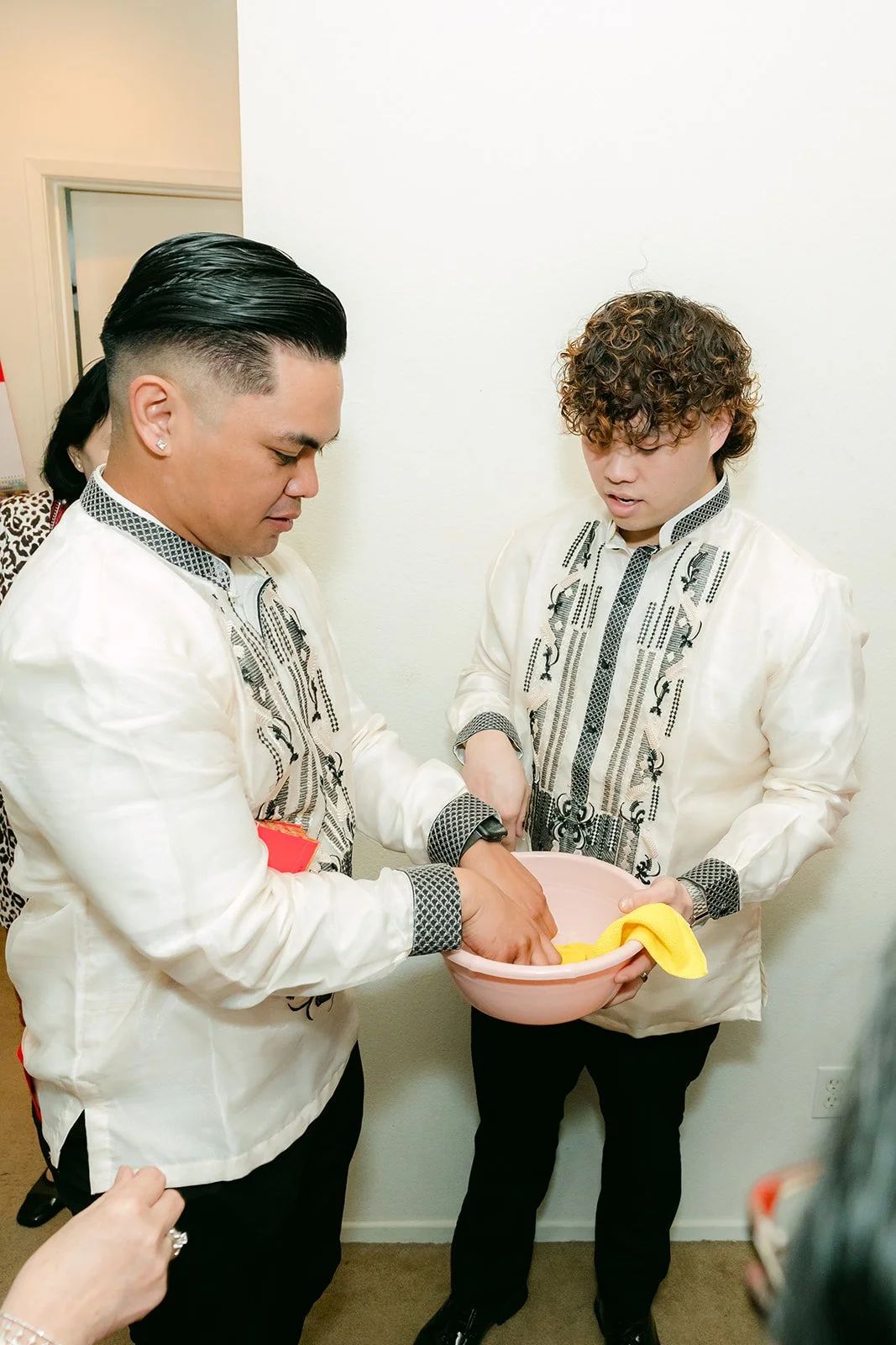 The groom and a groomsman counting red envelopes for the bridesmaids.